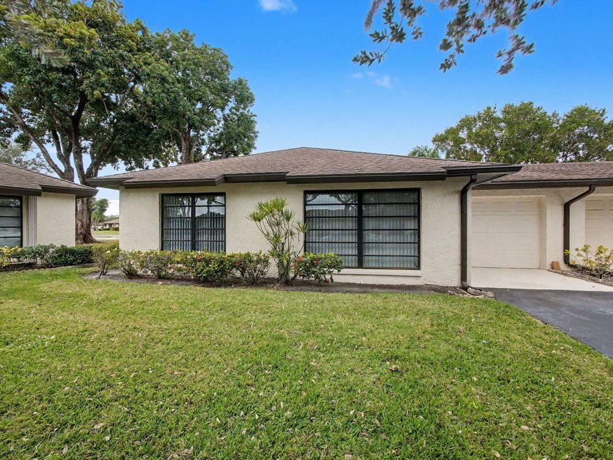 Well-maintained 55+ corner villa with a 1-car garage and tranquil lake views. Tile flooring throughout the living room, dining area, and kitchen. Updated kitchen features granite countertops, ample cabinetry, and a washer and dryer conveniently located in the kitchen. Spacious living room ideal for relaxing or entertaining. Large primary bedroom and second bedroom both offer comfortable carpeting. Updated bathrooms add a modern touch. Enjoy the enclosed patio with storm shutters and serene lake views. Greentree HOA includes roof maintenance, exterior insurance, water, cable, landscaping, common areas, and trash. Community amenities include six pools and six clubhouses. Ideally located near shopping, dining, entertainment, medical facilities, and easy access to I-95.
A/C replace 2022,