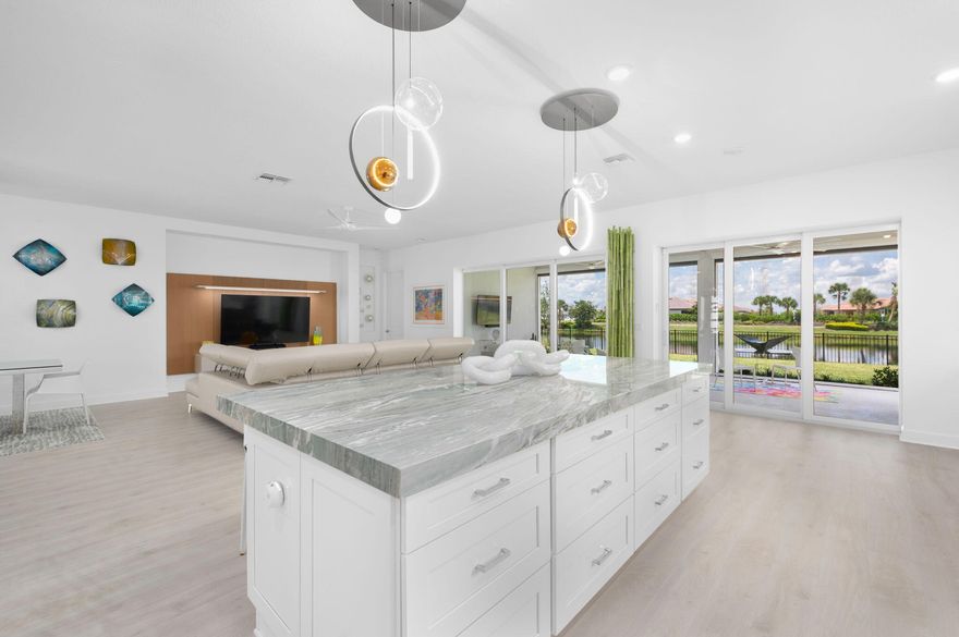 Welcome to the Esplanade 55+ gated community in Tradition. Where vacation never ends. This resort style community has something for everyone. Beautifully decorated Pallazio Model built by Taylor Morrison with no detail left out. Grand entrance with just over 3,000sqft of living. You're immediately drawn in with the breathtaking water view. Expanded lanai with motorized patio screens and outdoor kitchen. Gourmet kitchen with quartzite center island, pantry with electric, under cabinet lighting, upgraded glass showcase cabinets, built in cook top and combination microwave/wall oven (GE Monogram package) . Living room entertainment feature wall. Primary bedroom includes expansive walk in closet with built-ins, dual sinks with frameless glass shower enclosure. Inside laundry room with added storage cabinets. 2 car garage with additional storage. Other upgrades included Plantation shutters, custom lighting, upgraded ceiling fans, interior doors are solid core doors and exterior windows and doors are impact rated.  Water filtration system with r/0 on kitchen sink. Backyard is fenced in for your pets! The HOA includes lawncare, irrigation, cable, internet, security, gated entrance and clubhouse amenities.