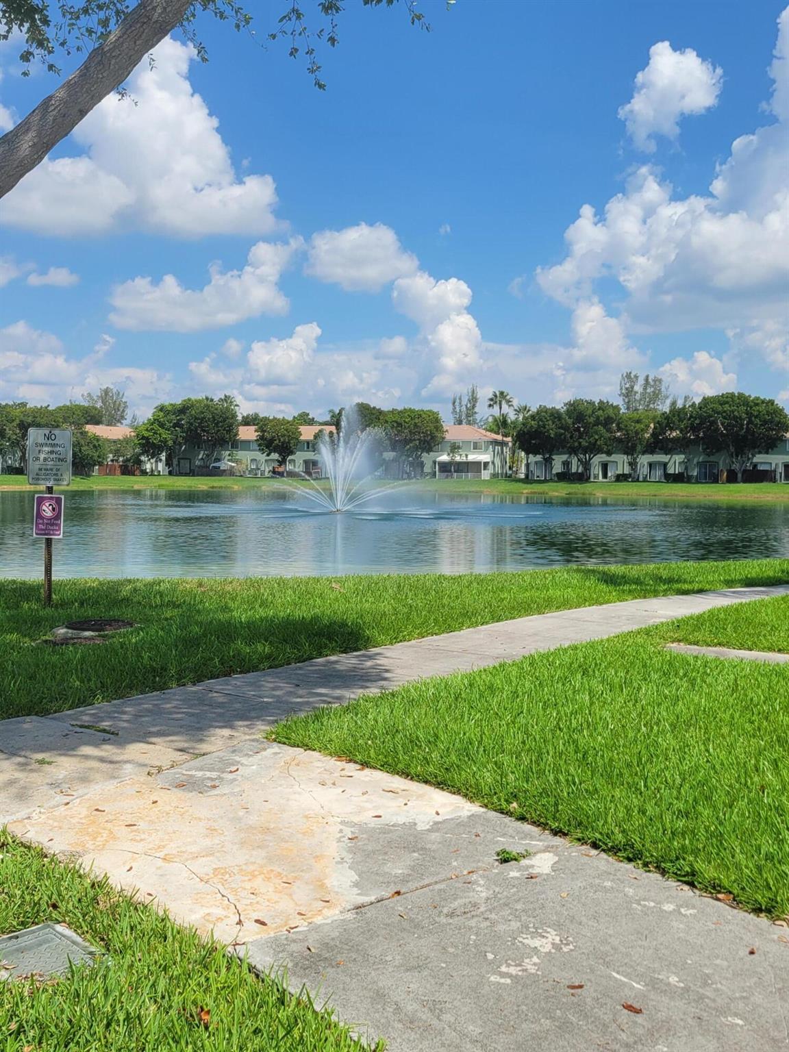 Well-kept gated community with pool, nice lakes and recreational areas. The unit has 3 bedrooms on the ground floor and 2 bathrooms. The master bedroom has updated flooring. The additional two bedrooms have new carpet. There is a storage shed in the yard. 2 parking spaces assigned directly in front of the unit. Very close to Turnpike. A Publix supermarket is a couple of blocks away.