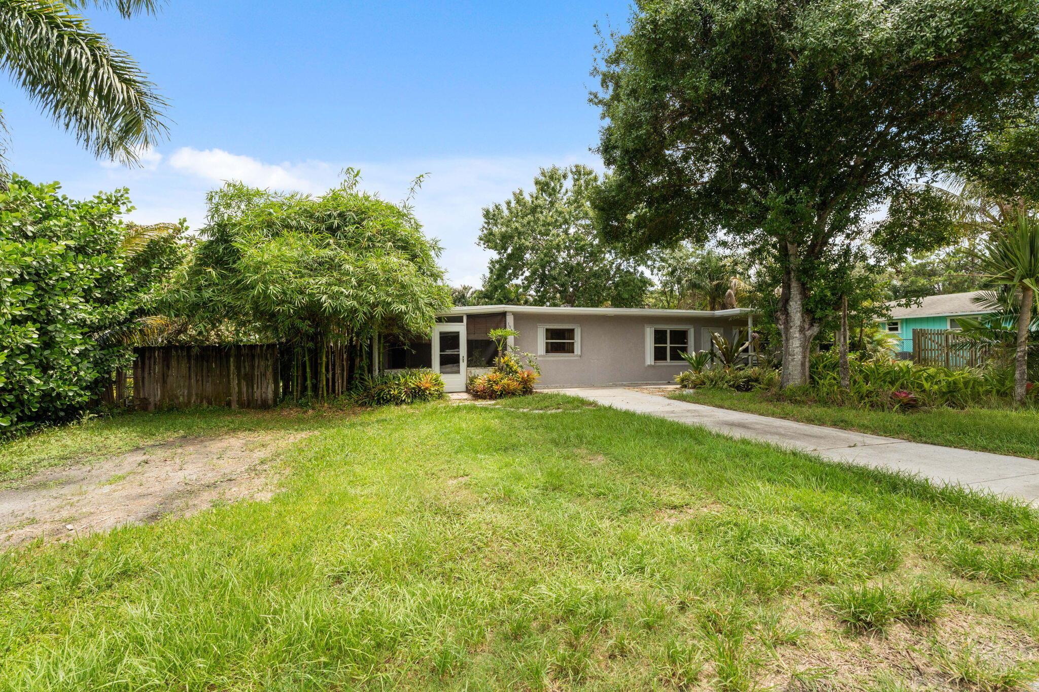 Palm City Starter Home Near Park and Bridge! Welcome to 1048 SW 36th Street -- a unique opportunity to own a spacious property with endless potential! This home is surrounded by mature trees and lush natural foliage, offering peace, privacy, and a connection to nature. The property includes two generous storage units, perfect for tools, hobbies, or extra storage needs. While the home could use a bit of TLC, it's a great canvas for your personal touch or investment vision. Located just steps from a family-friendly park and within walking distance to the bridge, this property combines convenience and tranquility in one ideal location.