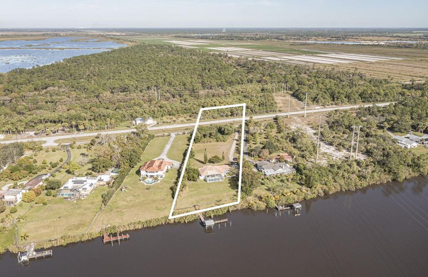 :BACK ON MARKET WITH BRAND NEW ROOF!! What a fantastic opportunity to own almost 2.5 acres of WATERFRONT property! This 3BR/2BA CBS home sits right on the deep waters with access to the Atlantic, Gulf and Okeechobee waterways! Features a private dock with a lift and a view that goes on forever!! Watch the boats go by from your screened lanai (new screens just installed) and recently updated pool. The home features tastefully updated bathrooms, a split bedroom plan, tile floors throughout and new water filtration system. The light and bright white kitchen boasts granite countertops, stainless appliances, gas range, wine fridge & a view of the river from your kitchen island! 1/2 acre of property across the road is perfect for a car enthusiast or to house your toys/RV etc. NO HOA