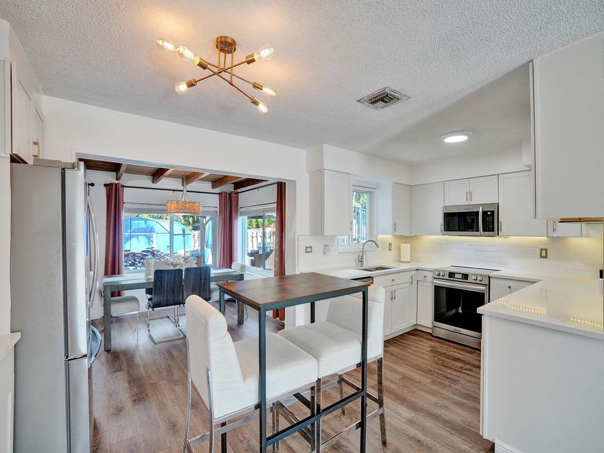 Discover your spacious retreat in the heart of Lloyd Estates! This charming home features an inviting open floor plan with luxury vinyl plank flooring. Step into the newly remodeled kitchen, where SS appliances, quartz countertops, and ample storage await. Rest easy with impact windows/doors, updated electrical panels, a 6-year-old roof & AC and new dual zone mini split. Entertain guests in the separate dining area or unwind in the cozy Florida room/den, with direct access to the meticulously maintained tropical backyard oasis. Outdoor living is a delight with a newly relined above-ground pool, decks, gazebo, and attached 2-car carport. Fresh paint, a laundry room, and proximity to parks and shops make this home the epitome of comfort and convenience. Schedule a viewing today!