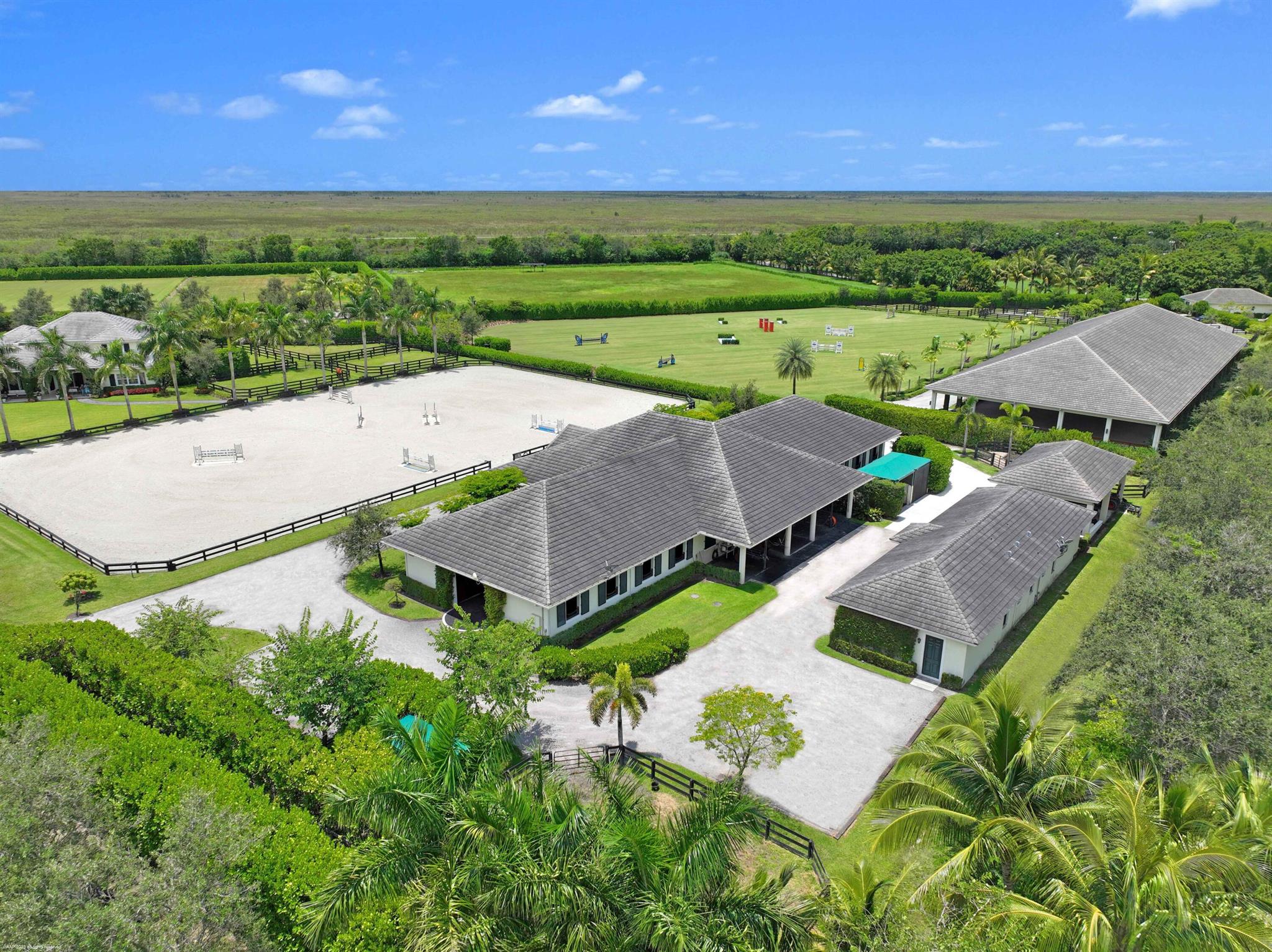 This incredible estate is perfectly situated on over 9.4 acres in The Saddle Club. Uniquely and beautifully, has it all; luxurious owners home, guest house, managers house, barn, jumping field, covered arena, sand arena and staff accommodations with ample separate storage buildings. Beginning with the 4-bedroom, 4-bathroom main house that was completely remodeled in 2021. Elegantly designed by New York designer, MDV Design no detail has been missed from the Pierre Frey and Hermes wallpapers to the custom Flos and Ralph Lauren lighting, to the fixtures throughout.Adjacent to the main house you will find a one bedroom, one bathroom guest cottage with its own living room and kitchenette equally tasteful designed; the perfect spot for guests to unwind.The airy 18-stall center aisle
