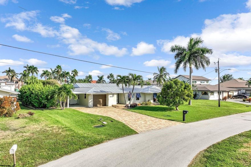 COMPLETELY UPDATED GULF ACCESS POOL HOME — 2 MINUTES TO OPEN WATER! Enjoy coastal living in one of Cape Coral’s premier boating neighborhoods with no bridges to slow you down. Features include a metal roof, paver driveway, screened courtyard, and lush tropical landscaping. Inside, the open concept design showcases floor-to-ceiling windows, wood-look porcelain tile, and a modern kitchen with shaker cabinets, granite counters, glass backsplash, large island, wall oven, cooktop, and farmhouse sink. Relax on the lanai with waterfront views, heated 9-ft pool, and 10K-lb boat lift with canopy and newer wrapped pilings. The primary suite offers dual sinks, quartz counters, walk-in shower with steam feature, and custom closet with washer/dryer. Furnishing package available!