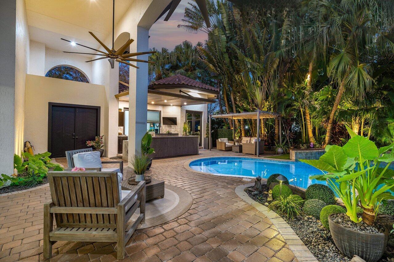 Welcome to this masterful, contemporary lakefront residence owned by a celebrity chef in Seasons of Boca Raton! As expected, the kitchen leads with a massive, backlit quartzite center island that should be referred to as a continent. The kitchen is powered by: 48' Miele gas cooktop with 6 burners + griddle, fully integrated 48' Miele refrigerator and a Miele Double oven with Steam/Convection combination and warming drawer. Dual Miele dishwashers, a custom stainless hood, and a porcelain & glass backsplash highlight this incredible space. The kitchen overlooks the bright and spacious family room that opens out to the one of a kind courtyard. Custom designer porcelain tile floors and soaring ceilings deliver a grand entrance that continues throughout the living room. See additional rem