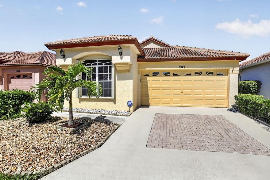 Beautifully updated lakefront single-family home located in the highly desirable gated community of Woodbine. Situated on a premium lot with expansive long lake views, this move-in-ready 2BR/2BA home with a 2-car garage offers stylish upgrades, vaulted ceilings, and an open, light-filled floor plan. Interior features include plantation shutters, a screened entry, updated flooring, and spacious living areas designed for comfortable everyday living and entertaining. The kitchen was remodeled in 2025 with modern cabinetry, quartz countertops and backsplash, stainless steel under-mount sink, and stainless steel appliances, with select appliances replaced in 2025 including the oven. The space is completed by a French-door refrigerator with water and ice dispenser.  Additional recent upgrades include new laminate flooring in the kitchen and baths (2025) and new washer and dryer (2025). The primary suite offers serene water views, custom closets installed in 2024, and an updated en-suite bathroom featuring a renovated walk-in shower completed in 2025/2026 with frameless glass enclosure, pebble accent flooring, handheld shower wand, updated vanity with quartz countertop, and modern fixtures. The soaking tub remains original. The guest bathroom was updated in 2024 with a new vanity, quartz countertop, framed mirror, and modern hardware. Plush bedroom carpeting was replaced in 2025 for added warmth and comfort. Enjoy relaxing lake and fountain views from the spacious screened lanai with custom shades, ideal for indoor-outdoor living. The finished 2-car garage was upgraded in 2024 with epoxy flooring, built-in shelving, and a slat-wall storage system for added organization and functionality. Major system improvements provide peace of mind and include a new tile roof (2022), plumbing replacement (2026), accordion hurricane shutters, and ADT security system with exterior cameras. Woodbine offers 24-hour manned gated security and resort-style amenities including 2 community pools, clubhouse with fitness center, tennis, pickleball, racquetball, volleyball, playground, sports field, shuffleboard, and sidewalks throughout the community. HOA includes cable and internet. Boat and RV storage may be available through the HOA for an additional fee, subject to availability and HOA approval. Conveniently located near shopping, dining, golf, beaches, and major highways. Welcome Home!