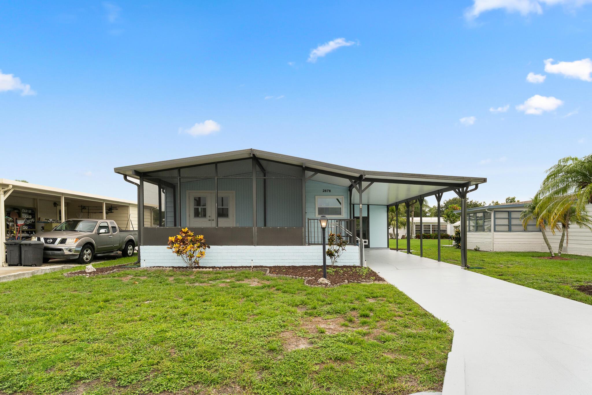 Welcome to this fully renovated 2 bedroom 2 bath home in the vibrant 55+ community of St. Lucie Falls. A full remodel featuring hurricane impact glass windows LVP floors and a modern kitchen equipped with new cabinets Carrara Quartz countertops and GE stainless steel appliances. New lower insulation and vapor barrier. Bathrooms updated with tiled showers and contemporary fixtures complemented by a tankless hot water heater and a new washer and dryer. Freshly painted inside and out, the home also includes walk-in closets, a 2022 A/C system and a 2017 roof. Community amenities include 2 clubhouses heated pools tennis pickleball bocce ball RV and Boat storage and access to launch a boat.
