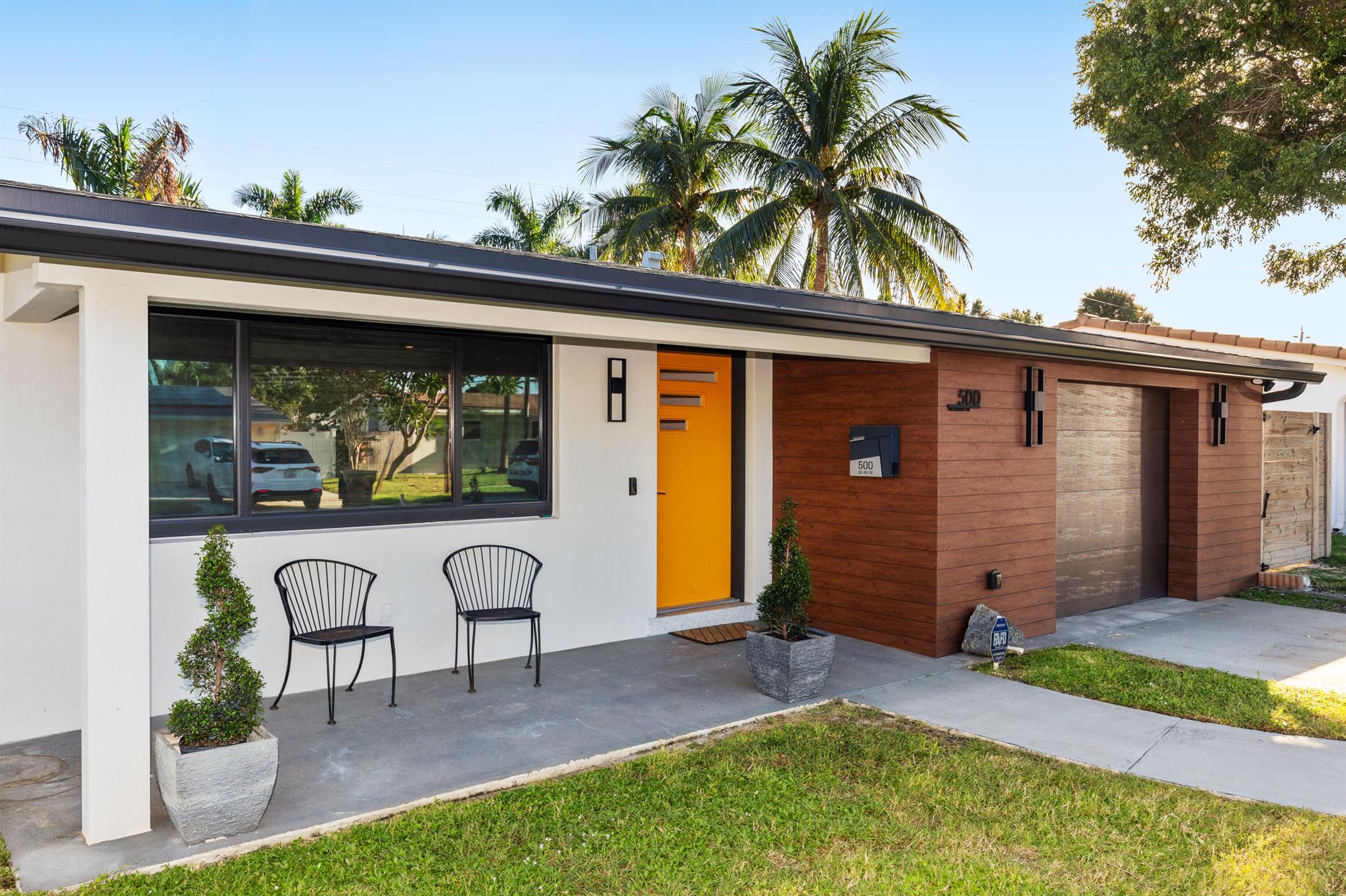 NO EXPENSE SPARED IN THIS EXCEPTIONALLY DESIGNED MID-CENTURY GEM! Just minutes to Deerfield Beach and close to everything you need, this beautifully renovated home is unlike any you've seen in the area! Step inside to discover a light-filled, thoughtfully designed interior that blends mid-century charm with modern luxury. The custom chef's kitchen is a true showpiece: featuring tons of solid custom wood cabinetry, handmade Zia tile backsplash and bar wall, rose gold accents, a custom range hood, pot filler, Kohler fixtures, GE Cafe Series appliances, and quartz waterfall countertops. The kitchen flows seamlessly into a sunny dining area overlooking the large saltwater pool with Southern exposure! The covered patio (with electric blinds for sunsets!)is perfect for entertaining.