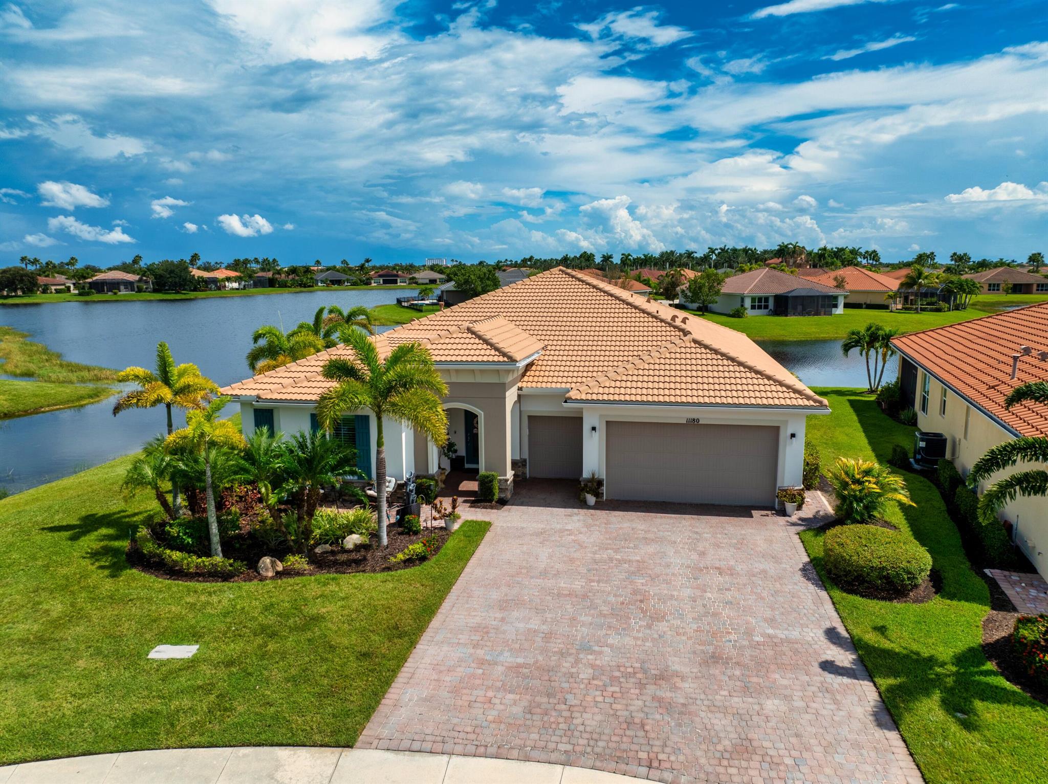 This stunning upgraded 3-bedroom, 2.5-bath home with office is set on a prime quiet cul-de-sac lot, offering over 2,400 sqft of beautifully living space. Throughout the home, you'll find crown molding, tray ceilings, upgraded lighting & fans plus built-in speakers in both the living room and lanai. The GARAGE is a standout with a 4-foot extension, golf cart garage, premium NewAge 24'' deep steel cabinets, shelving, HyLoft storage racks, & a floored attic with a elec pulley for safe access. Recent updates: new AC, dishwasher, & hot water heater, for long term use. Two guest bedrooms share a full bath, while a stylish half bath is perfect for guests. Enjoy open 180 lake views from your 24x54' travertine lanai complete with a  7x20.5' heated fountain saltwater POOL, gas firepit & BBQ. w b