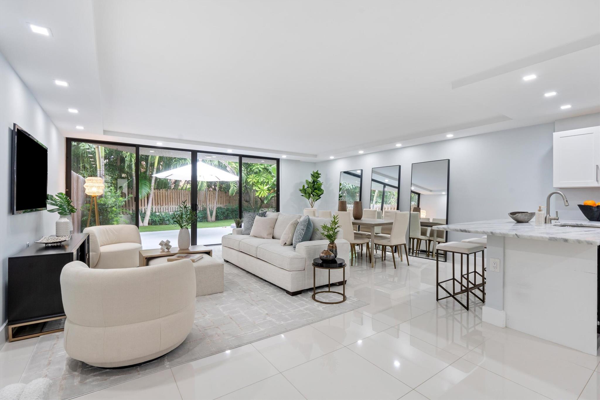 LOCATION LOCATION LOCATION! Ideally located across the street from the beach and 8 blocks to Atlantic Avenue, this totally renovated 3 bedroom, 2.5 bathroom townhouse has it all: complete impact glass, 24'' x 24'' white porcelain flooring, LED lighting throughout, a huge backyard with lush landscaping and turf with plenty of room for seating as well as electricity and water to build out an outdoor kitchen. The white and bright kitchen features soft close cabinetry, stainless steel appliances, modern stone countertops and there is a nook with access to the front patio (a perfect place for your morning coffee or to set up a workstation). Upstairs is the Primary Bedroom and two additional guest bedrooms. The Primary Bedroom has a double door entry and features soaring ceiling
