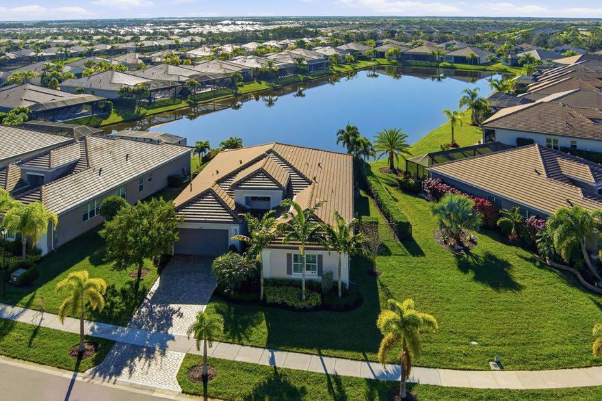 Welcome to 11698 SW Coronado Springs Drive, a meticulously maintained residence located in Valencia Cay at Riverland, one of Port St. Lucie's most desirable 55+ communities. This exceptional Vintage and Crown Collection home sits on an oversized, prime pie-shaped lot with rare southern exposure and is one of Riverland's only long-lake, southern-view pool homes, offering breathtaking sunrise-to-sunset water views and an unparalleled living experience. Designed for the ultimate Florida lifestyle, the property features additional yard space on both sides and a private backyard that serves as a true entertainer's retreat. Highlights include a heated and chilled saltwater pool with a natural boulder rock waterfall, an in-water umbrella table with seating, sealed travertine decking, an extended lanai, a quartzite outdoor kitchen with a built-in stainless steel grill, a hurricane-rated roll-down screen enclosure, and a cozy fire pit. And of course the most BEAUTIFUL views. Inside, the bright open-concept layout is ideal for both everyday living and entertaining. The chef's kitchen is a true entertainer's dream, appointed with level-five cabinetry, premium finishes, an oversized island, high-end appliances, and bar seating for four. Smart home features provide seamless control of the pool, outdoor screens, and window treatments. A versatile den can function as a third bedroom, and the one-car garage has been converted into a gym, hardwired for air conditioning. The spacious primary suite is a peaceful retreat with stunning long-lake views, a beautifully oversized primary bathroom, and two generous walk-in closets. Natural light fills the living spaces, creating a warm and inviting atmosphere throughout the home. Located in the vibrant Riverland community, residents enjoy world-class amenities including resort-style pools, multiple restaurants, the RiverFresh Café, a state-of-the-art fitness campus, pickleball courts, an Arts and Culture Center, and an active social calendar filled with clubs and events. Set in a quiet, well-maintained neighborhood with convenient access to shopping, dining, parks, and major roadways, this home offers an exceptional blend of luxury, comfort, and lifestyle. Whether you are seeking a full-time residence or a place to enjoy the Florida lifestyle, this beautiful home presents a rare opportunity to own one of Riverland's most unique waterfront properties. Extensive upgrade list available.