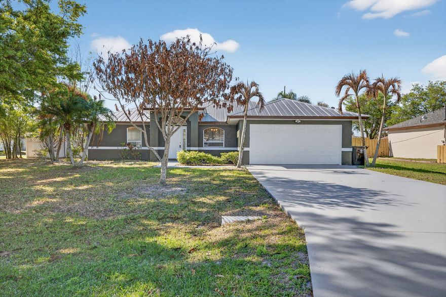 Move-in ready home featuring a 2021 metal roof, ideally situated on a corner lot highlighted by a stunning mature oak tree that delivers exceptional shade, character, and curb appeal.  This property stands out with rare versatility, offering a permitted detached structure with endless potential, ideal for a future in-law suite, home office, workshop, or income-producing space.  Inside, the home features a true split floor plan with 4 bedrooms and 2 bathrooms, including a primary suite with direct sliding door access to the pool. The layout offers both a formal living and dining area, along with a spacious great room designed for everyday living and entertaining. Step outside to your private screened-in pool, the perfect Florida lifestyle upgrade, complemented by expansive patio space and a functional yard ideal for outdoor activities, gardening, or relaxing.  Bring all your toys with not one, but two garage spaces, plus additional room for parking. Conveniently located near golf courses, Saint Andrews Plaza, shopping, dining, and everyday essentials.