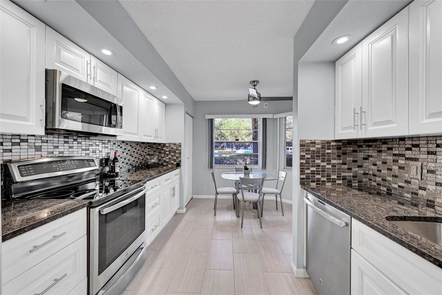 Light and Bright, beautifully remodeled 2bedroom/2bath ground floor condo featuring serene lake/pool view right outside of your back door. Move in ready residence offers: remodeled kitchen+ granite countertops, all glass, clean mosaic backsplash, all wood cabinets +drawers along with a large 36" wide pantry +nice appliances. Remodeled bathrooms showcasing new showers, granite +quartz countertops with modern all wood vanities, mosaic glass tile & modern fixtures. Ceiling fans in every room.  Enjoy the convenience of parking just steps from your front door and easy back door access to the pool/lake. No pending assessments and good reserves. 55+Community with lots of amenities: tennis, courts, pickle balls, bocce, 19 pools, billiards rooms, theater, gym, clubhouse, and much more. A must see!. VACANT/CLICK ON SHOWING ASSIST