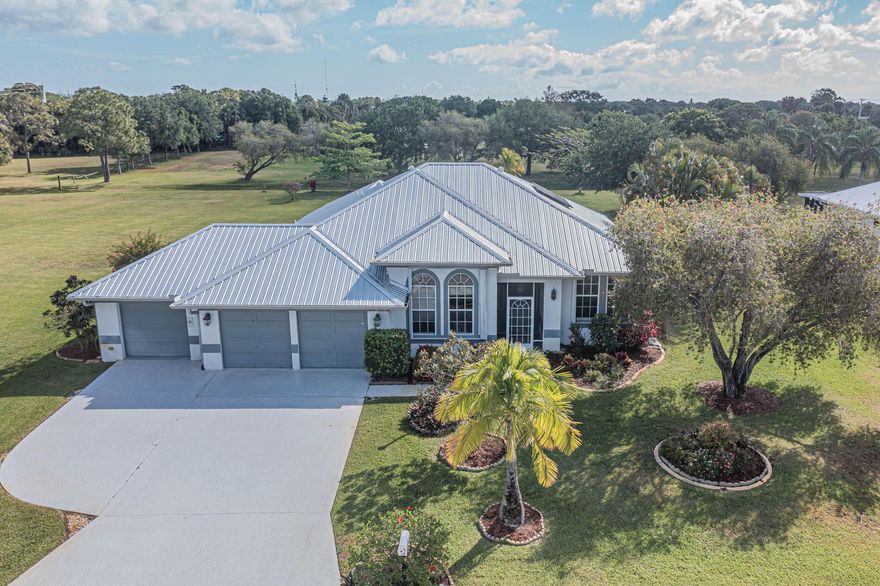 LOCATION!!!! This wonderful home is located in the wonderful area of Sandpiper Bay. Over 1/2 acre with views of The Saints Golf Course in the back and lake view across the street in the front.  Three bedrooms plus a den, formal dining room, huge covered/enclosed lanai with portable hot tub (that stays), 3 car garage, and HURRICANE ROOM (CBS Construction). Metal Roof 2019, H2O Htr 2020, A/C 2017, new gutters on front of home, accordion shutters on most openings plus panels, solar panels (paid in full), portable generator hookup, sprinkler on well, new carpet in living room. Kitchen has granite and newer Frig, D/W and Microwave. Master has THREE walk-in closets (2 in bedroom, 1 in bath). Master bath has dual sinks and shower.