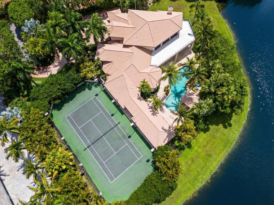 Nestled on a serene cul-de-sac within the prestigious gated community of Long Lake Estates, this sprawling lakefront estate on more than an acre offers the ultimate in luxury living.  Spanning 7,577 of interior square feet and boasting 7 bedrooms, 9.5 baths, including a private guest house, every detail has been thoughtfully designed to accommodate grand scale entertaining while maintaining the warmth and comfort of every day living. Soaring ceilings create an immediate sense of grandeur, complimented by w richly wood paneled office that offers both sophistication and privacy.  A spacious formal dining room sets the stage for elegant gatherings, while the grand great room complete with wet bar is perfectly designed for effortless entertaining. The chef's kitchen with breakfast area flows seamlessly into a large family room with a cozy fireplace, creating the heart of the home.  Both the great room and family room overlook the breathtaking backyard, blending indoor elegance with serene outdoor beauty.  The expansive primary suite is conveniently located on the ground floor and serves as a true private retreat, featuring a spacious sitting area along with separate his and hers bathrooms and custom closets.  A powder room, guest suite and laundry room complete the first level.  Upstairs, you'll find three additional bedrooms, along with an oversized ensuite that offers incredible flexibility-perfect as media room, game room, or additional living space for relaxing and entertaining.  French doors open to a charming private balcony.  Outdoors, enjoy a spectacular free-form pool, private tennis court with professional lighting, summer kitchen, wet bar, multiple seating areas, 350 feet of lakefront, and a separate guest house that can also function beautifully as a cabana.  This home is truly an entertainer's paradise.