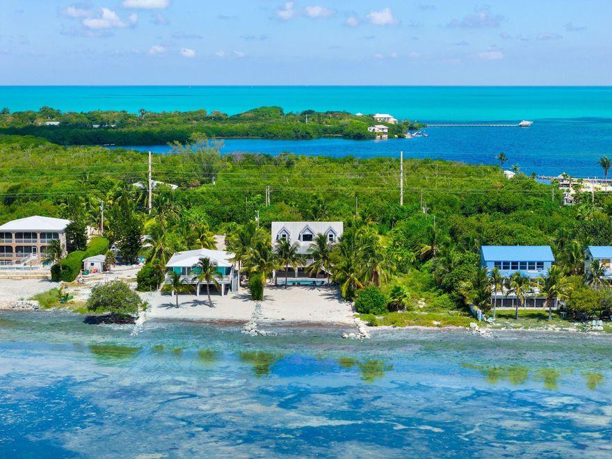 Dreaming of your own beach house in the Keys? Welcome to Casa de la Playa in Grassy Key, where island living meets luxury. Set on over 1/2 acre, this 4bed/4bath retreat offers sweeping ocean views, a private sandy beach & resort-style pool just 5 min from Marathon airport. Inside, enjoy a bright open liv area, gourmet kitchen w/S.S. appliances & windows framing endless views. The 2nd-level veranda is perfect for sunrise coffee or sunset cocktails. Outdoors, relax by the pool or entertain with ocean breezes. Short-term rental approved, this home is both a private escape & smart investment. Recent upgrades include impact win/doors, Hardi Board siding & parking for cars/boats. Casa de la Playa is near world-class fishing, diving, dining & boating. A rare chance to own paradise in the FL Keys.