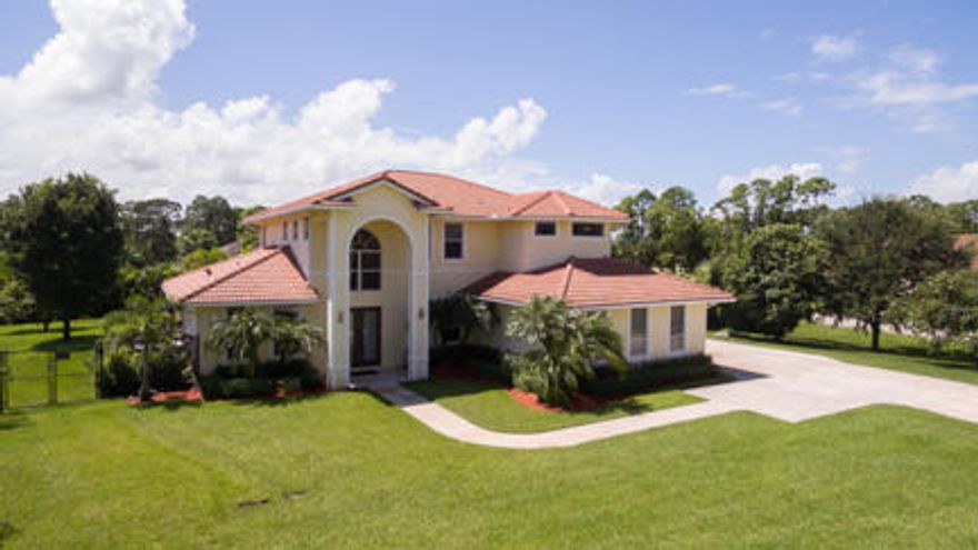 BEAUTIFUL, WELL MAINTAINED 2 STORY CUSTOM BUILT MEDITERRANEAN STYLE HOME. JUST OVER 3000 SQ. FT. LIVING AREA, ON OVER AN ACRE AND LOCATED ON A PAVED ROAD. 4 BED (4TH BEDROOM DOWNSTAIRS FOR GUESTS OR MULTI FAMILY LIVING) 3 BATH AND A TRUE 3 CAR GARAGE.  A TRUE CULINARY HAVEN, DOUBLE CONVECTION OVENS, INDUCTION COOKTOP, PREP ISLAND AND WALK IN PANTRY. DOWNSTAIRS 10' CEILING, ENGINEERED WOOD FLOORING , BUILT IN SURROUND SOUND, OPEN FLOORPLAN WITH EXPANS IVE VIEWS OF POOL, SPA, LARGE PATIO AREA AND TIKI. TWO A/C'S '21, WATER HEATER '25, POOL HEATER '23, EXTERIOR PAINT 2018. BACKYARD IS DOUBLE FENCED, 20' ARECA PALMS FOR PRIVACY, ENTIRE YARD HAS ZONED IRRIGATION. EXPANSIVE DRIVEWAY WITH ADDITONAL CAR PAD SO GARAGE IS NOT BLOCKED.  SPACIOUS PRIMARY BEDROOM, HIS/HER CLOSETS IWTH CUSTOM BUILT INS RAINFALL SHOWER, SPA TUB  SEPERATE HIS AND HERS VANITIES. CONVENINETLY LOCATED JUST OFF OF 110TH AVE FOR EASY ACCESS TO NORTHLAKE, TURNPIKE AND 95 FOR EASY COMMUTING. CLOSE TO NEW AVENIER  AND WESTLAKE TOWN CENTERS FOR SHOPPING (BRAND NEW PUBLIX) AND DINING.