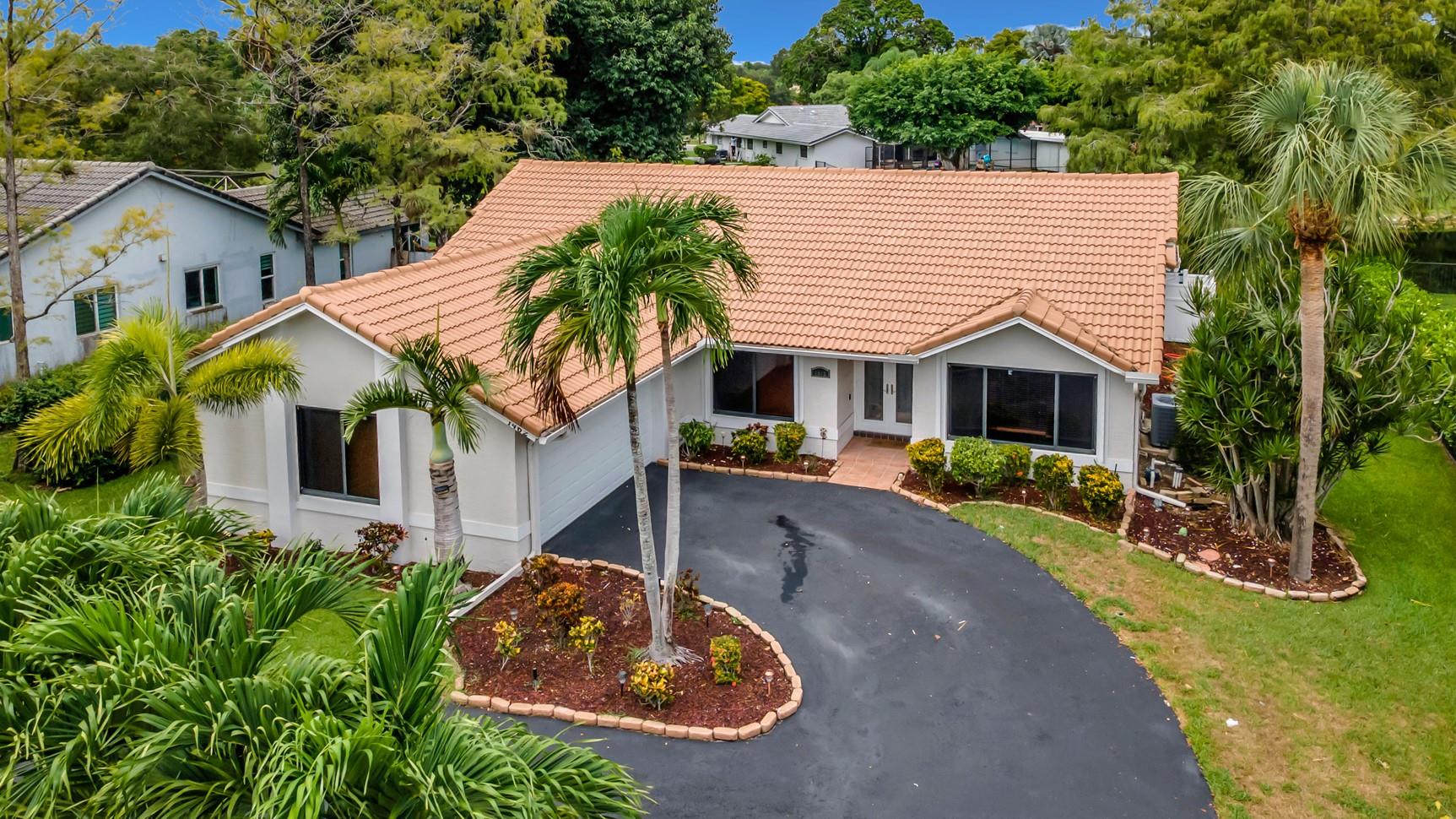 Welcome to 1462 NW 97th Terrace in the highly sought-after Maplewood community of Coral Springs. This 3-bed, 2-bath home sits on an expansive 11,250 sq ft lot with no HOA. Features include a split floor plan, vaulted ceilings, updated baths, and a primary suite with double sinks and direct pool/patio access. The kitchen overlooks a screened patio and Van Kirk pool with sunshelf, travertine deck, and canal views. Fenced yard with partial turf area. Impact windows, accordion shutters, circular drive, 2-car garage, new A/C, insulation, and water heater. Close to A+ schools, shopping, Coral Springs Walk & more. Move-in ready!