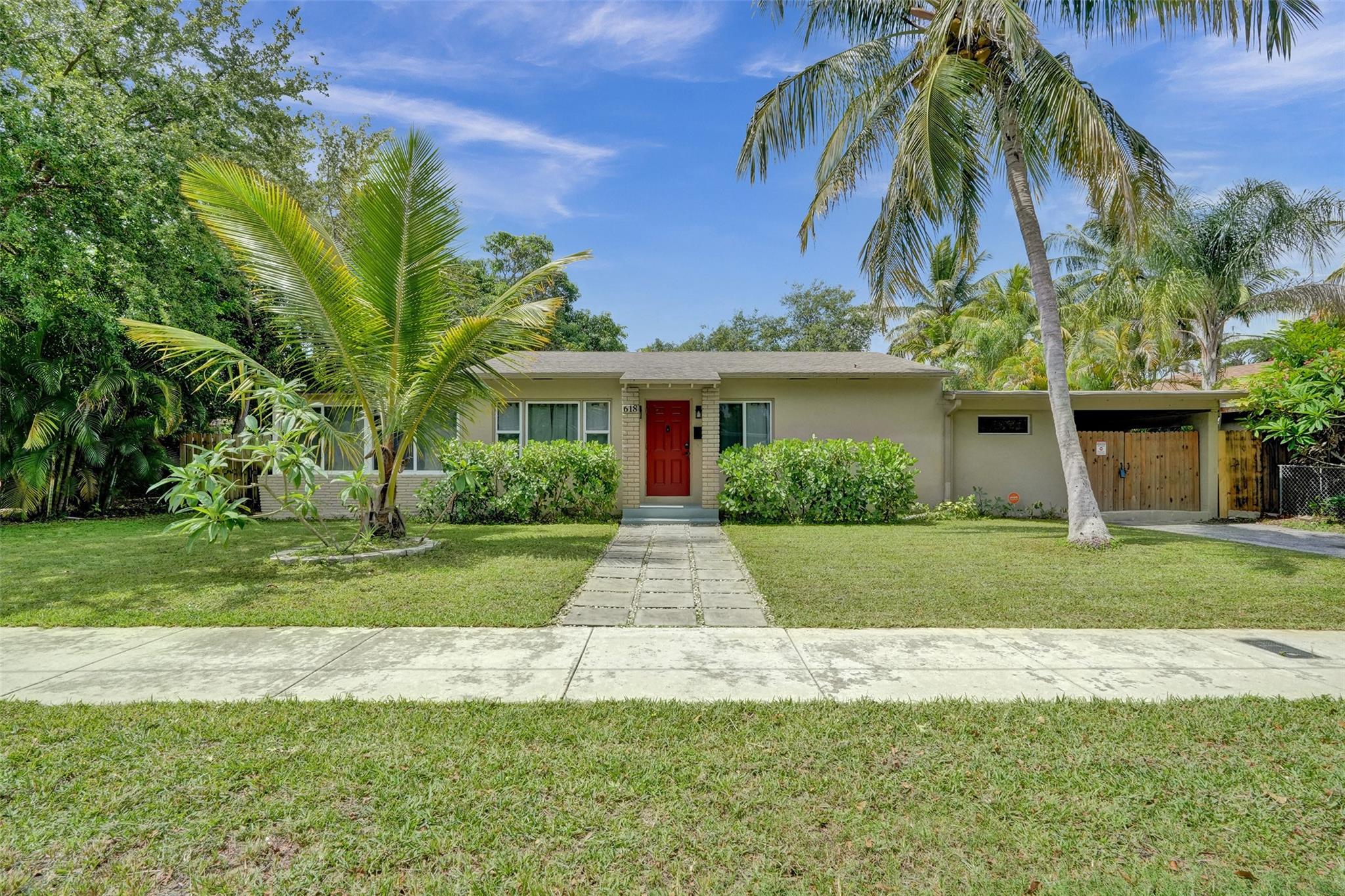 Set on an expansive double-lot with nearly 11,000 sq. ft. of land, this spacious 3-bed, 2-bath home features a renovated kitchen, updated and expanded primary bath, impact windows, newer roof, AC, & Water heater, as well as PVC plumbing throughout for peace of mind. Options are endless with the inclusion of a versatile utility room off the kitchen that's ideal for an in-law suite or gym. The convertible sunroom has been closed off to serve as a 3rd bedroom, home office, or creative space. The oversized back yard is a blank canvas of possibility with space for a pool, patio, gazebo, or summer kitchen, and also features mature mango trees for shade. The gated carport on the side offers both privacy and security. Conveniently located and full of potential, this house is ready for your vision.