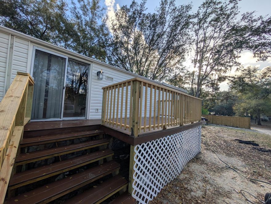 Welcome to this exciting opportunity! Fee simple land with a 2 bed / 2 bath mobile home on a 0.33-acre lot. Features include a new partial wooden fence in front facing the street, an 8-year-old metal roof, brand new vinyl flooring throughout, and a new mini-split system. Interior highlights cabinets refreshed with a new coat of paint and a brand new stand-in glass shower door in the primary bathroom. Property also has a new septic tank and well, electric and water available, and hookups ready for your washer and dryer. Plenty of parking. Enjoy the brand new deck for entertaining. Motivated seller - submit all offers.