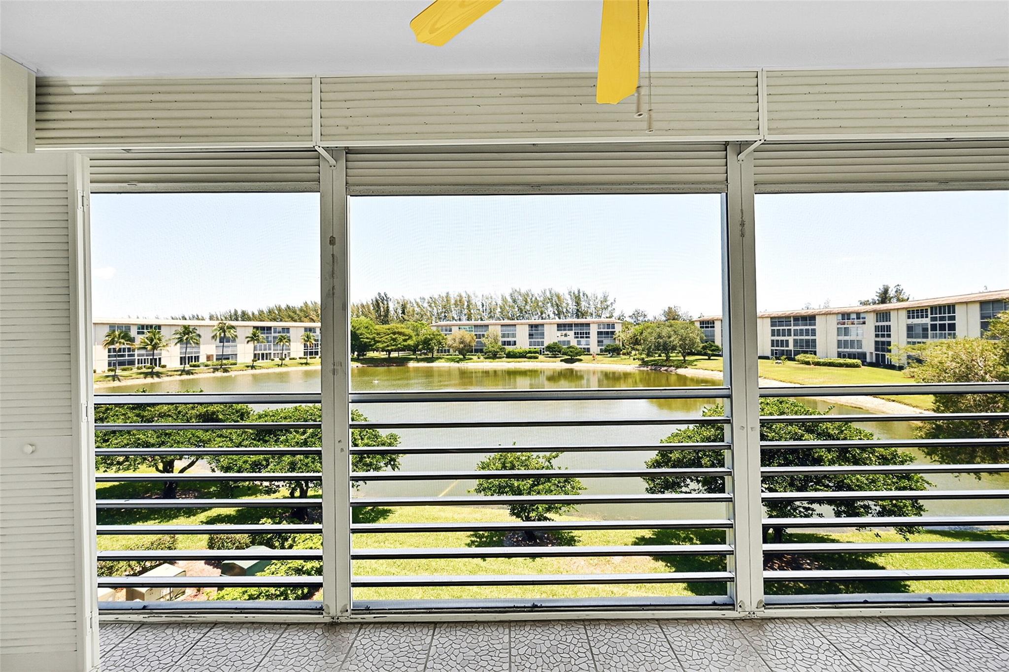 You will be pleasantly surprised when you enter this condo featuring all vinyl and laminate flooring. The updated kitchen boasts granite countertops and has been professionally painted, making it move-in ready. The air conditioning system is newer, installed in 2021. Enjoy a panoramic wide water view with a fountain, especially lovely in the evening when the fountain is illuminated. The large eat-in kitchen is equipped with updated appliances. Be sure to check out all the photos, and then see the condo for yourself. This floor plan includes the largest patio in all of Wynmoor.