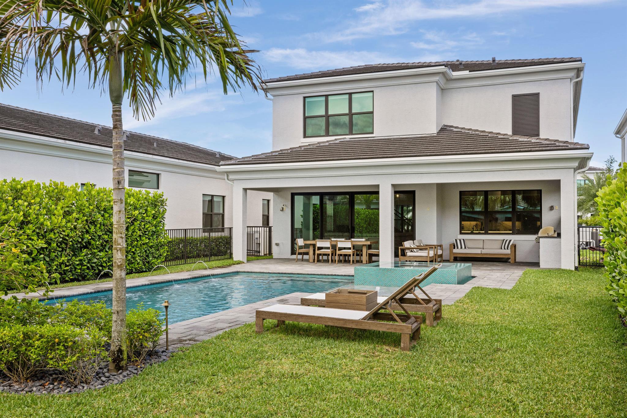 Modern sophistication meets effortless indoor-outdoor living. Vaulted ceilings & oversized windows with plenty of natural light.Custom kitchen with wood-paneled cabinetry & bar, large island, & Miele appliances including gas cooktop, double ovens, built-in coffee station & hidden fridge/freezer. The covered lanai, summer kitchen, pool/spa & sun shelf create a true outdoor oasis. Upstairs has 4 bedrooms & a loft, including a primary suite with 2 custom closets & a spa-style bath. All guest rooms are en-suite with custom closets. A glass-enclosed office completes the main level. Located on the largest lot for this model with space to add a fire pit, putting green & play area.24/7 security,resort-style pool, clubhouse, & fitness area. Moments from A rated schools,shopping, dining & beaches.