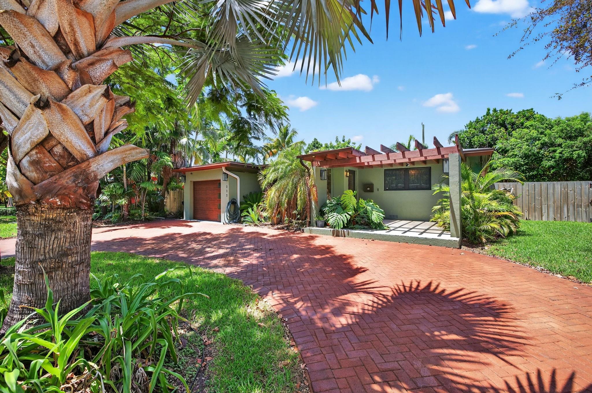 ARCHITECTURAL GEM ON DOUBLE LOT! One of South Middle River's most coveted properties blends mid-century Floridian elegance with Craftsman details. Enchanting front lanai pergola welcomes guests. Expansive living spaces merge formal and casual entertaining. Beautifully refinished wood floors. Chef's kitchen features upgrades and breakfast bar and overlooks the sparkling pool and fenced outdoor oasis. Split-bedroom layout includes guest wing with mini-split a/c & private patio. New roof in 2025. Newer A/C. 1 car garage. Circular paver driveway. Prime location in peaceful enclave near Wilton Manors entertainment district, minutes to downtown Fort Lauderdale and beaches. Don't miss this one!