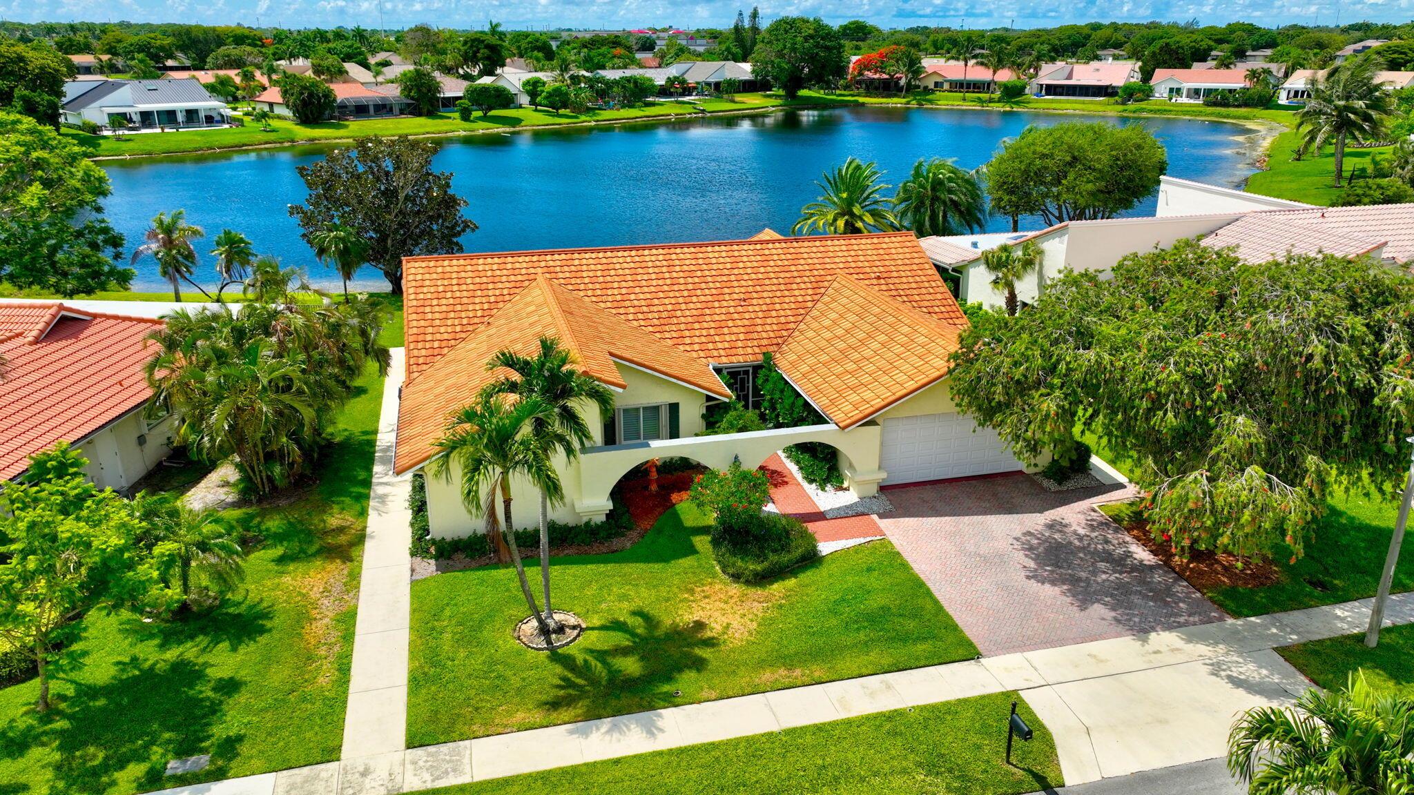 Welcome to 2542 SW 23rd Cranbrook, a beautifully maintained lakefront home located in the desirable gated community of Estates of Silverlake in Boynton Beach. This spacious single-story residence offers a harmonious blend of comfort, elegance, and serene outdoor living. Boasting three generously sized bedrooms and two and a half bathrooms. As you enter, you're greeted by soaring vaulted ceilings and abundant natural light, with large windows and sliding glass doors framing picturesque views of the lake. The kitchen flows seamlessly into the family and dining areas, creating a warm and inviting space for everyday living and entertaining. Outside, a spacious patio provides the perfect setting for relaxing or hosting gatherings, all overlooking 80 feet of tranquil lake frontage.