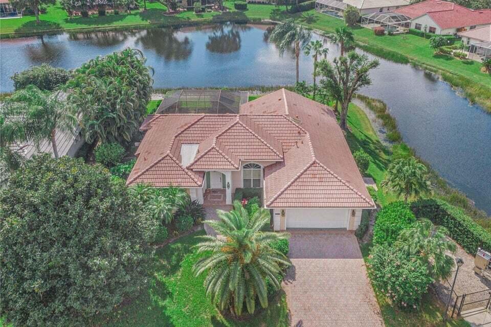 Exceptional price adjustment! This exquisite 3-bedroom, 3-bathroom residence in PGA Country Club Pointe has been lavishly enhanced, including a complete CPVC water pipe system overhaul in 2021 and a comprehensive 3 bath remodel in 2022, complemented by a new electrical panel installed in 2023. Nestled on a generous lot with breathtaking lakefront vistas, the home boasts a thoughtfully designed split floor plan featuring a spacious master suite with a walk-in closet and a luxurious ensuite bathroom showcasing dual vanities and an expansive shower. The open-concept kitchen, adorned with a Quartz center island and breakfast bar, effortlessly flows into the formal living room, dining area, and family room, all providing multiple access points to the inviting pool and vast backyard.