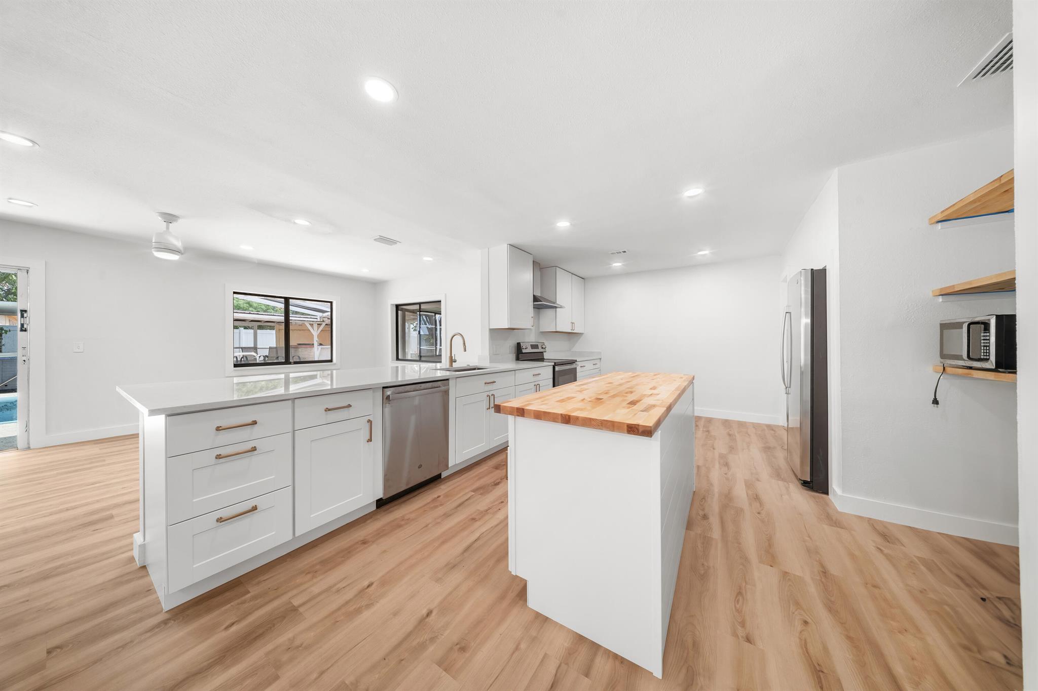 Motivated Seller offering 10k seller concessions! Welcome to this beautifully renovated 3-bedroom, 2-bathroom home that is perfectly positioned on an oversized corner lot in a quiet neighborhood. Step inside to find luxury vinyl flooring throughout, modern appliances, and a stylish kitchen featuring quartz countertops and a butcher block island--perfect for entertaining. The updated, natural stone fireplace adds warmth and charm to the spacious living area. Both bathrooms have been completely remodeled with spacious double vanities and contemporary finishes. Outside, enjoy your private backyard complete with an in ground pool, relaxing hot tub, and outdoor kitchen area. The home also includes a solar electric system for reduced electric bills! *Pool photos are not updated yet.