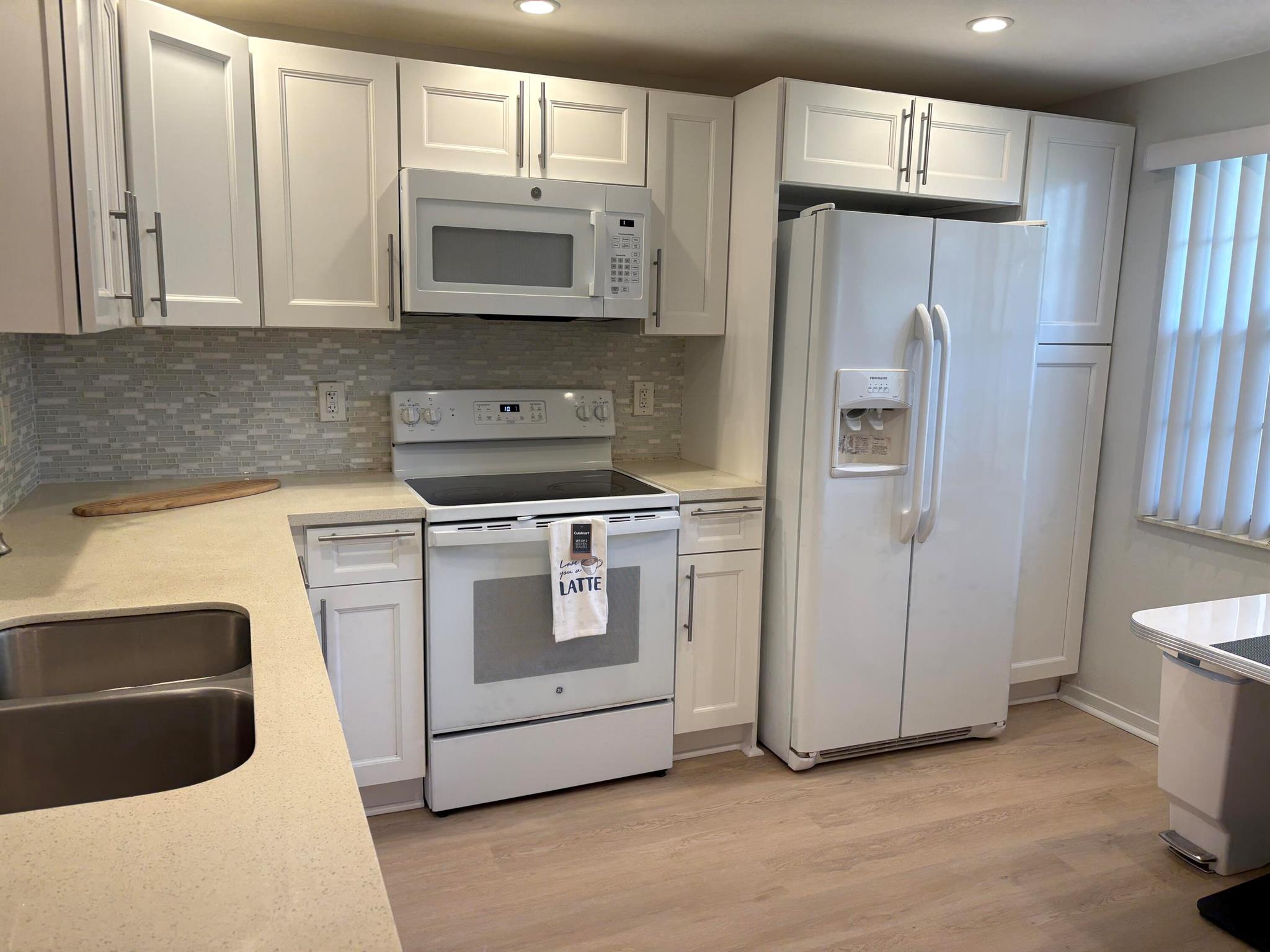 Welcome home to this beautiful SUNNY 2 bed/2bath GROUND FLOOR condo, with parking spot nearby front door for easy access from shopping, etc. Steps bus and poolPartially furnished Just painted,new laminate like flooring throughout.Remodeled kitchen features a bar, custom built high-end white wood dovetailed cabinetry with soft-close doors and drawers, pull-outs, crystal clean engineered white quartz counter tops, Kohler high-line faucet, newer dishwasher and recessed lighting! Enjoy a custom made white and steel diner table, great for breakfast, coffee or dessert! The morning sun pours through front window with a palm tree view from the east facing kitchen, and long beautiful sunsets can be viewed on the back patio, which faces west, and you can walk direct