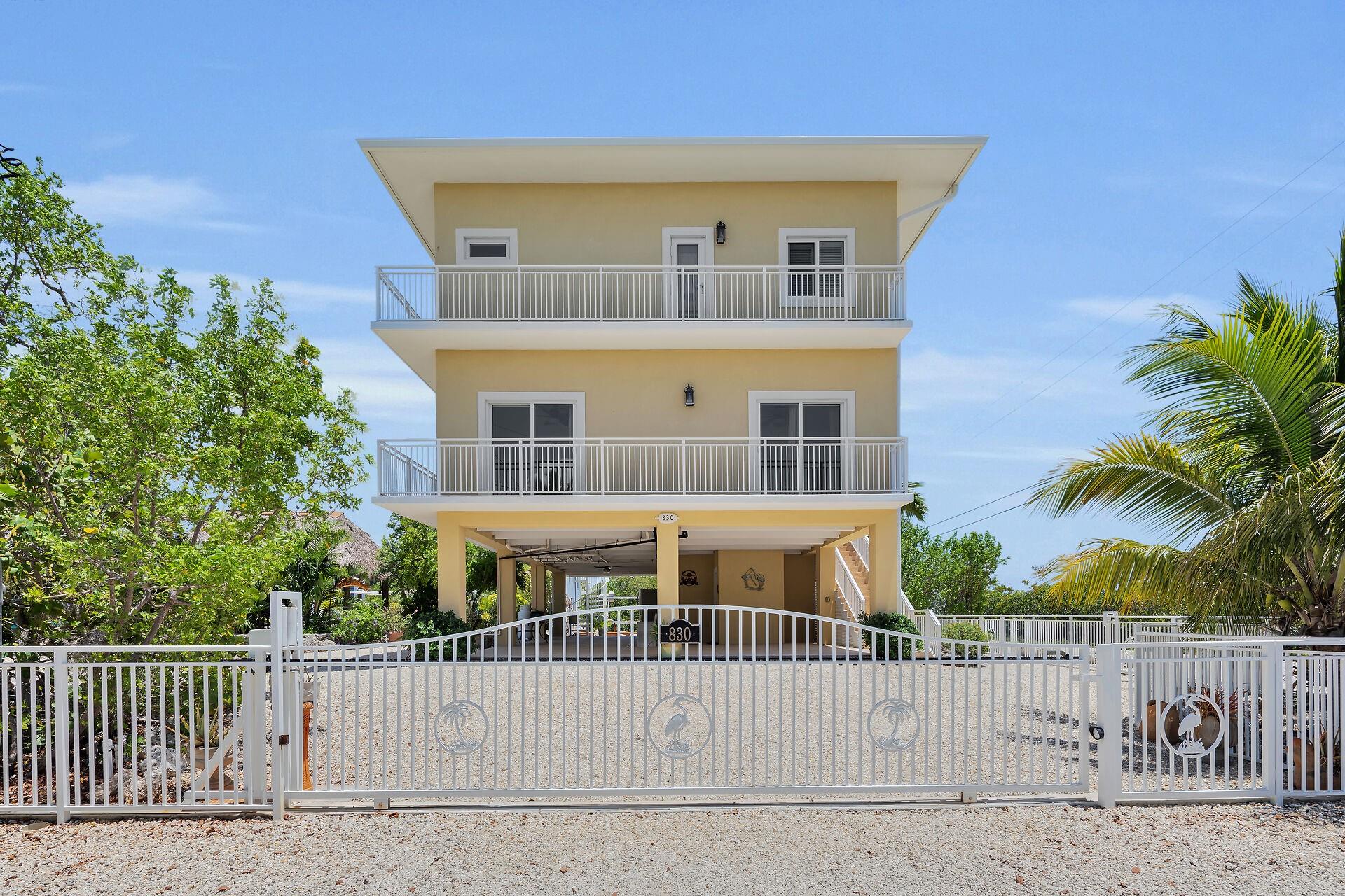 Builders Own Waterfront, 4 Bedroom, 4 Bath Pool Home on Corner Lot with Elevator, Dock, Tiki Hut and Breathtaking Views! This builder spared no expense on his family home! Nestled on a dead-end road across from Pennekamp Coral State Park this private, resort-like property boasts a double lot on a quiet corner with stunning views from every window. Custom powder-coated aluminum fencing with decorative native birds encloses the oasis with 2 walk-thru and 3 rolling vehicle gates. Strategically placed coral walls, lush herb gardens, palms hiding brilliant-colored orchids, and charming monarch butterfly bushes all serve to complement the delightful garden paradise. A crafting/potting cottage with dollhouse front porch, electric, countertop sink