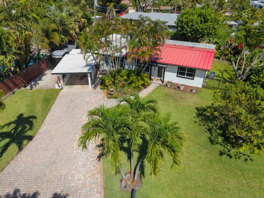 Meticulously refreshed 3-bedroom, 2-bath home on a large lot (10,701 sf) in quiet enclave, just a short distance to premier dining and entertainment. Designed for comfort and efficiency: METAL ROOF (2019) - 8 yrs warranty remaining, A/C (2025), Electric Vehicle charger, upgraded electrical panel, IMPACT windows doors, re-lined sewer pipes, NEW APPLIANCES, tankless water heater, smart toilets, new exterior stucco and reframed windows, flat roof (remaining 3 yrs warranty), new ceilings and drywall, custom closets, and integrated dimmable LED lighting. An expansive screened-in Florida room overlooking a private garden with a Rain Bird irrigation system on well water with plenty of space left for a custom pool. Abundant additional storage, clean ducts, foam insulation, and termite protection. Windows have Zebra Shades and Blackout blinds. Herb Garden in back and carport has herbs growing successfully - Dill, Lemongrass, Oregano, and Tomatoes. New photos taken on Wednesday, Showings Start on Thursday.