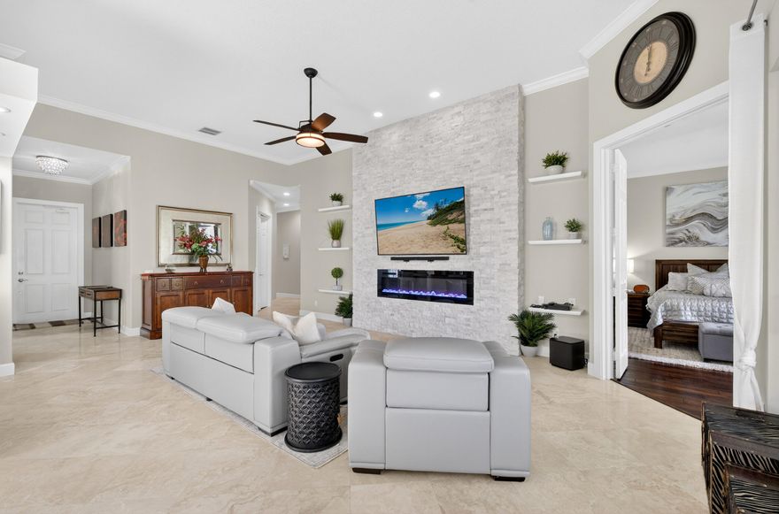 Water front fully furnished, remodeled, turnkey 3-bedroom, 3-bath home with den, built by Divosta with solid CBS construction and poured concrete walls for lasting durability and peace of mind. Covered screen patio with water view. This meticulously upgraded home has all new impact tinted windows and doors, upgraded handles and accordion shutters. Step inside to find polished marble flooring throughout the main living areas and engineered hardwood floors in the bedrooms and den. The home features crown molding throughout, enhancing its elegant feel. The chef's kitchen and all bathrooms boast granite countertops, custom soft-close cabinetry, and newer stainless steel appliances. Additional custom cabinetry in the laundry room with newer washer and dryer 2025. Tankless hot water heater.  Fully fenced backyard for your pet to exit off patio pet door.  The spacious family room is designed for relaxation and entertainment, complete with NEW leather reclining sofas, a stunning stone wall fireplace, mounted TV, soundbar, and subwoofer system—all included. All TV's stay. Located in a desirable manned-gated community, the HOA provides exceptional value with services including premium cable, alarm monitoring, full landscaping and irrigation, tree trimming, roof cleaning, and periodic exterior painting—ensuring truly low-maintenance, stress-free living. Residents enjoy resort-style amenities including a lap pool, resort pool with on-site restaurant, post office, and scenic walking paths connected by picturesque bridges. Conveniently located near the Wellington International (WEF), as well as shopping, dining, and medical facilities, this home offers both luxury and lifestyle. A rated Schools. Schedule your private tour today and request the full list of upgrades—this exceptional home won't last!