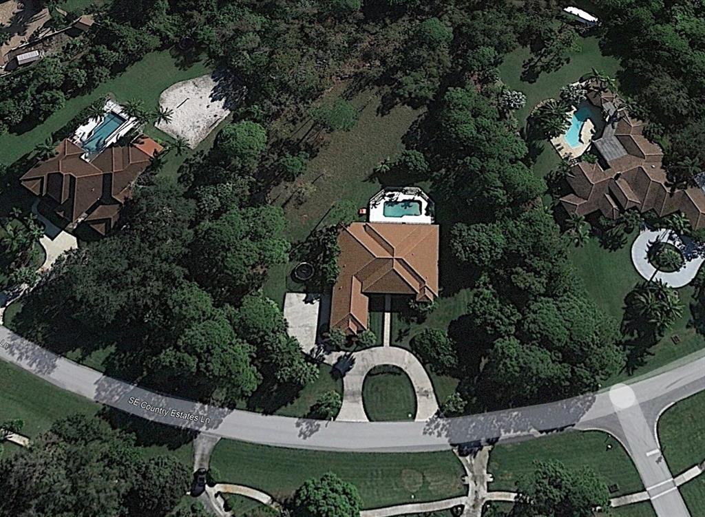 ISLAND COUNTRY ESTATES, Custom solidly constructed C.B.S. Estate Home, 12 to 13 ft volume ceilings, lots of custom details, P. B. Terra-Cotta Barrel Tile Roof in 2018, & 2021 new seamless gutter system. 4 bedrooms, 3 baths, in Secluded Gated Sanctuary, 1.62 acres cleared & sodded, oaks and fruit trees, boundary lines are in thick foliage for complete privacy, Room for Tennis court etc. All-new in 2022 Custom-built kitchen and in the adjoining Great Room, a new custom-built entertainment wall. New tankless water heater and new flooring throughout. The whole house was sealed and painted inside & out. With its tranquil views of the acre back garden and pool, the Grand Lanai has the perfect southeast exposure for year-round entertainment & enjoyment. 'A Great Place To Be'!