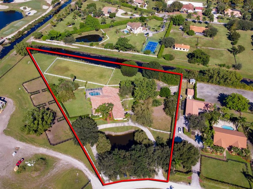 IDEAL LOCATION..and only 20 Minute Hack to WEF in elegant Saddle Trail Park. The home is situated on an oversized 2.96 acre CORNER lot. Western sunset view over fairway of Golf Course, and bounded by canals on west & north property lines.  A rare offering!! 200 X 100 grass ring & existing Four stall barn. Ample property for a twelve stall barn, 2 grooms apts.,  paddocks, and ring. 5 bedroom, 4 bath home offers an open split floor plan, large rooms & renovated kitchen with fabulous views. Huge deck & oversized pool overlooking large grass paddocks & sunsets... Perfect for outdoor entertaining & grilling.