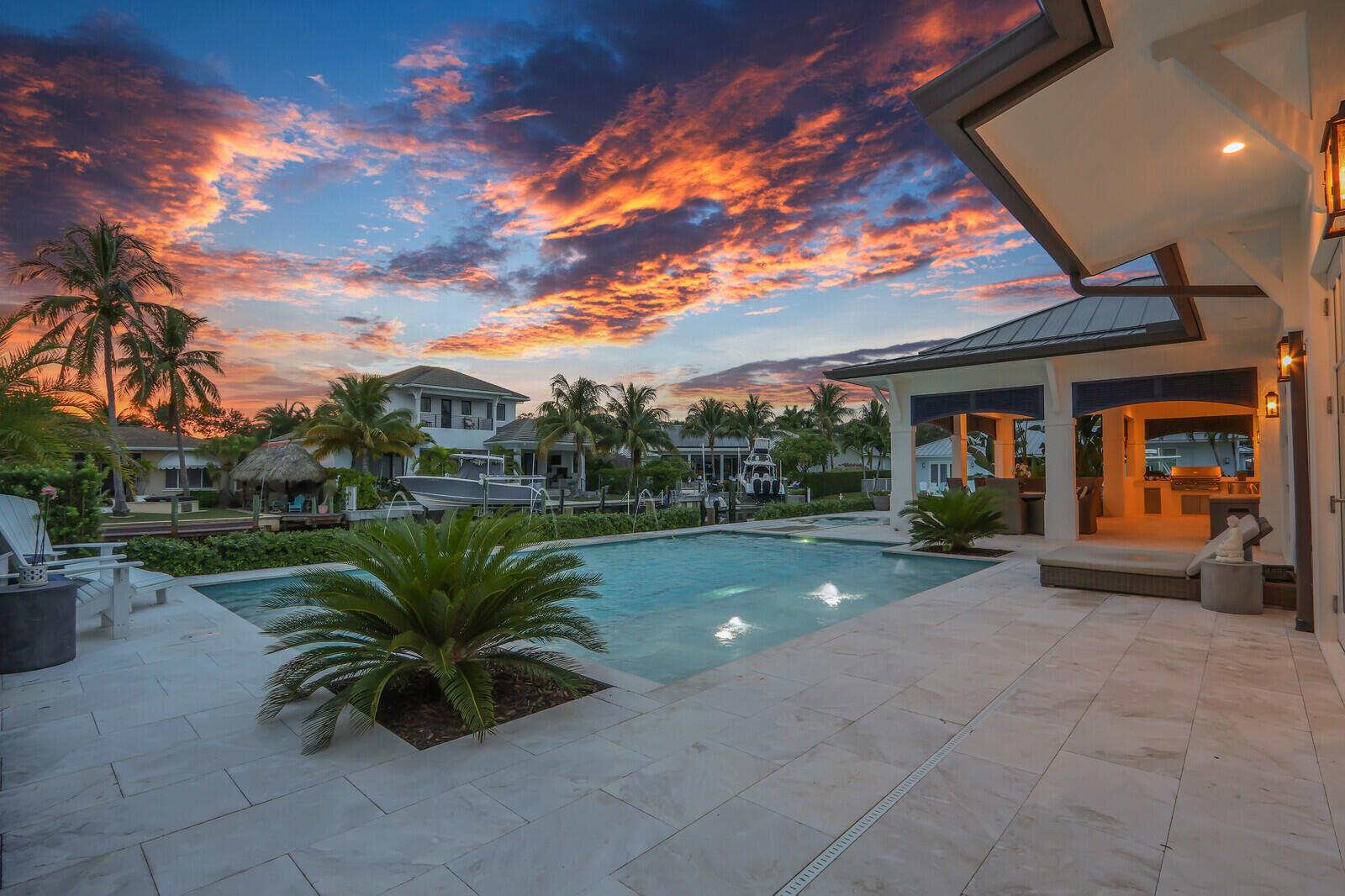 Gorgeous new-construction waterfront home in the heart of Jupiter! Situated on a rare corner lot at the end of a quiet cul-de-sac, this residence offers over 230' of water frontage with direct river, Intracoastal, and ocean access.The spacious 4-bedroom, 4-bath single-story ranch-style home features a split floor plan and Bahamian-inspired design. Highlights include custom mahogany louvered front and garage doors, Bahamian-style shutters and details, high-end impact windows and French doors, French oak beach-style hardwood floors, volume tray ceilings, and vaulted tongue-and-groove ceilings in the foyer and covered patio.The open floor plan is ideal for entertaining, anchored by a chef's kitchen from Palm Beach Cabinet Co. with an oversized island, Wolf propane stove with ...