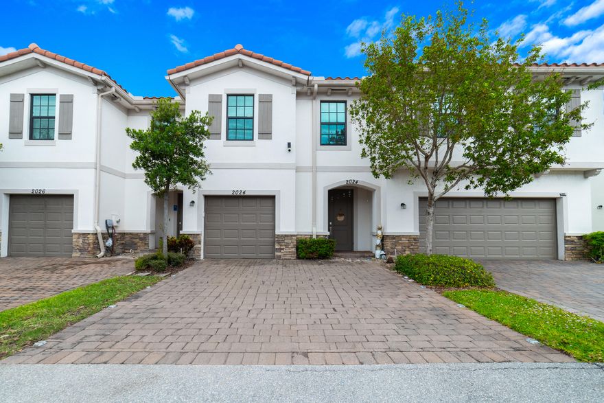 Welcome to this beautifully appointed waterfront townhome in the gated community of Arbor Parc, offering 4 bedrooms and 2.5 bathrooms. Built in 2020, this residence showcases a thoughtfully designed open floor plan with large neutral tile throughout the main living areas and a striking accent wall that enhances the living space. The kitchen features granite countertops, stainless steel appliances, a pantry, and convenient countertop seating, with a half bath located on the main level for added functionality. Impact-resistant windows and doors provide added safety, energy efficiency, and peace of mind. Upstairs, the spacious primary suite includes an ensuite bath with a walk-in shower, accompanied by three additional bedrooms and a full bathroom.  Wood-look luxury vinyl plank flooring extends throughout the upper level, offering both durability and style.  Enjoy tranquil lakefront views from the private, fully fenced backyard, complete with a paver patio and landscaping. A paver driveway offers parking for two and leads to the attached one-car garage. Residents of Arbor Parc enjoy gated access to the community, clubhouse, pool, spa, and tot lot, enhancing the overall lifestyle experience.