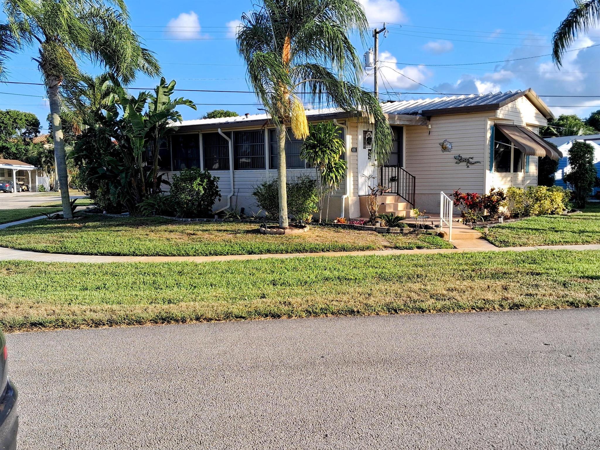 Corner lot sought after, well maintained manufactured home in a very friendly, active age 55+ community that's resident owned. NO lot fees! 1 time land share fee $750 refundable at resale. Turnkey all furniture and appliances included, full size washer/dryer in home, newer central A/C & water heater, Aluminum roof coated every few years, nice bright sunroom entry with wall A/C unit, kitchen island for entertaining, complex heated pool just refinished & clubhouse with many free concerts, BBQ's, games day, holiday parties, shuffleboard, bocce, petanque courts, golf driving cage, motorcycles & golf carts allowed, close to I95 and Turnpike, WPB & Ft Laud airports, 5 miles to beach, oversized shed 160 s.f. half bathroom & A/C unit, can be guest house or shelter, Sun shade patio, Hurry!