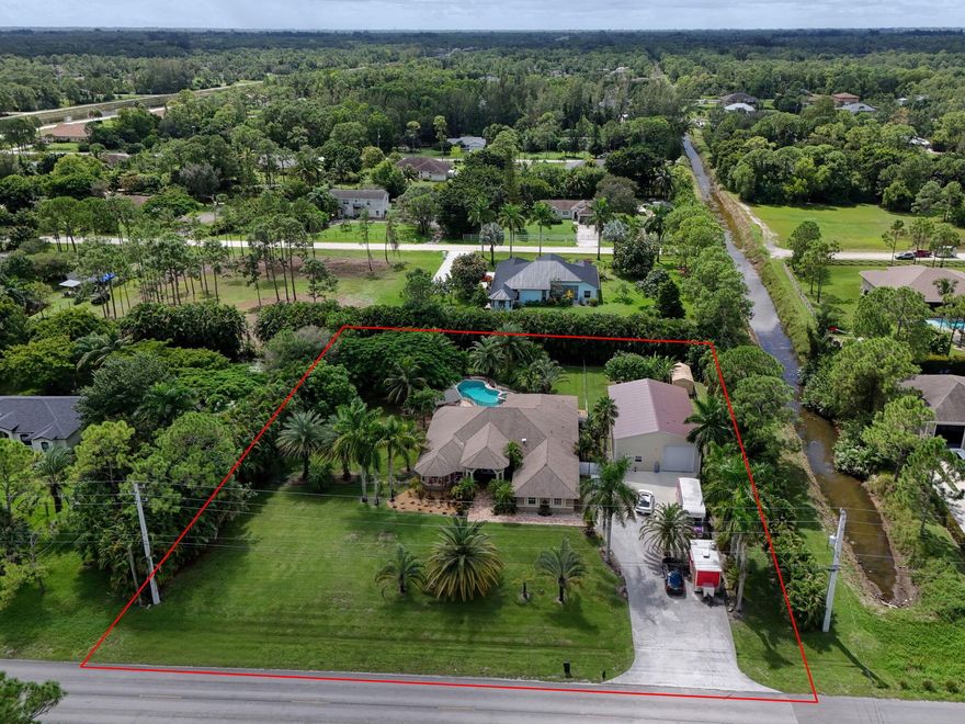 Discover a rare opportunity to own a private paradise with over 3,000 sq. ft. of living space on 1.37 acres. This spacious POOL home features 2 Master Suites, open floor plan, new kitchen. SUMMER KITCHEN (build in 2023) with grill, refrigerator, and keg cooler, perfect for entertaining. The 3-car garage includes a 2-car bay currently finished as an A/C flex room. In addition, a free-standing 1,700 sq. ft. insulated and fully air-conditioned building (build in 2023) with an office, half bath WAREHOUSE space & GARAGE w/ floor plate car lift. Paved road access, abundant storage makes this property ideal for both personal enjoyment and business use. Great location, 5min. from brand new Publix Shopping Plaza at Avenir Town Center (Walgreens, restaurants & more) on Northlake & Coconut Blvd)