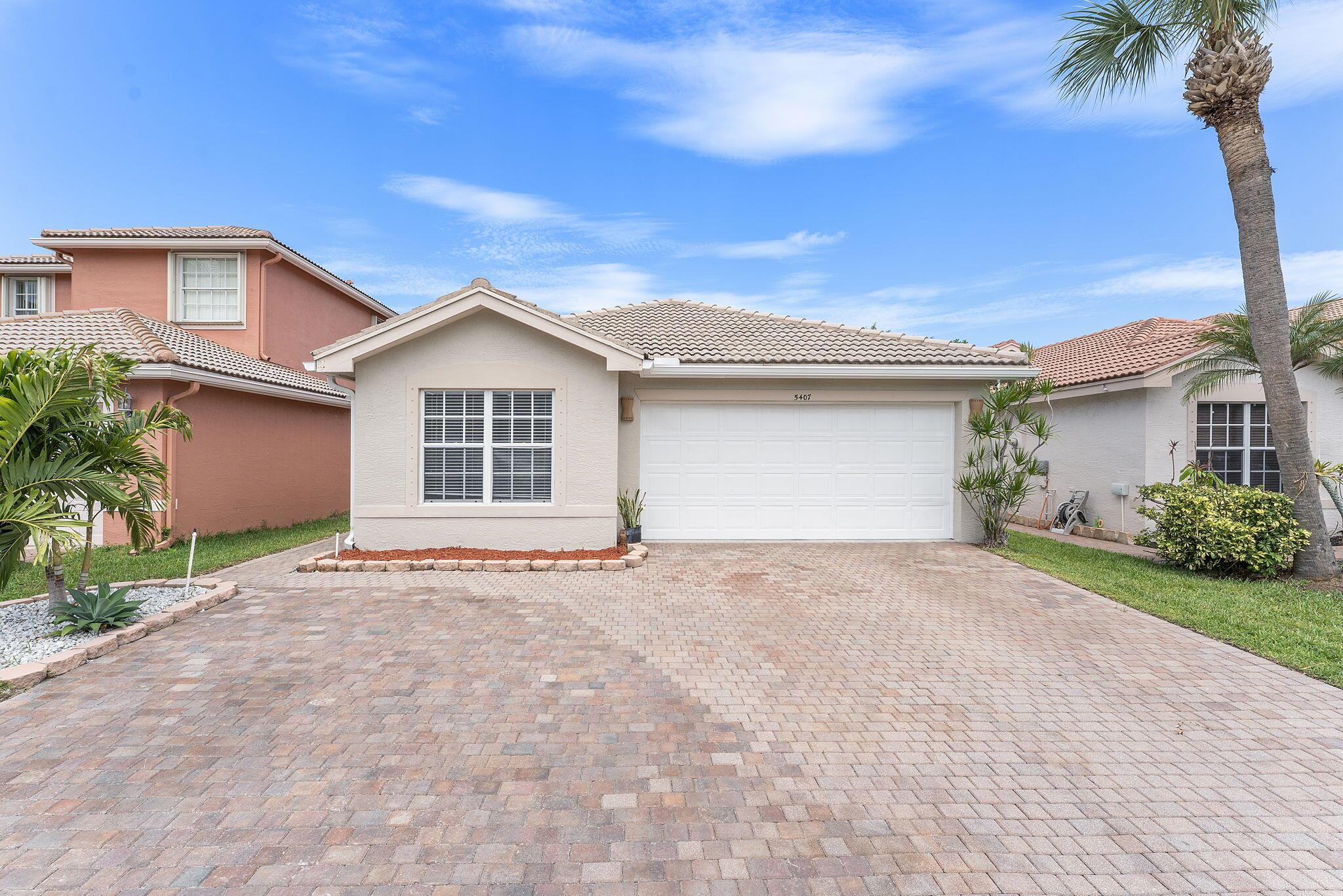 This well-maintained 4 bed- 2 bath single-family home in Greenacres offers a practical open floor plan with clean, modern finishes. The kitchen features stainless steel appliances, light-colored cabinetry, and dark countertops with a convenient breakfast bar. Throughout the home, you'll find a mix of tile and wood-look flooring, with recessed lighting and ceiling fans in main living areas.