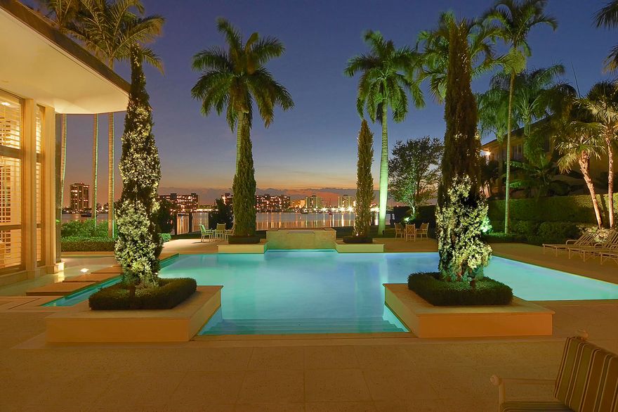 This Lost Tree Village gem has formal gardens and mature royal palms which line the entry and lead you to the gracious front door. As you step into the foyer you are struck with the subtle sophistication of every detail in this unique home. Natural coral stone and the finest oak floors complement the floor to ceiling windows. The light streaming into the common rooms is uplifting and changes with each season. This custom built home offers the finest construction, architectural beauty and sophistication. With over 8,800 square feet of air conditioned space, and 11,071 total space, endless entertaining options present themselves. A music room accommodates two concert grand pianos and the formal living room with large fireplace & wet bar overlooks some of the area's most extraordinary views.