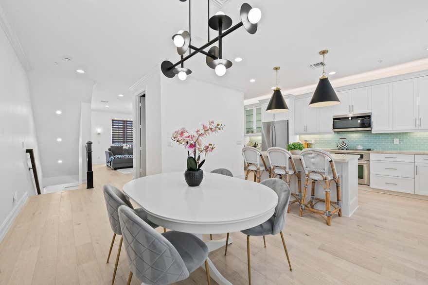 Located along Pineapple Grove, this stunning 3-story townhome is just three short blocks from Atlantic Ave and minutes from the beach! Built in 2014, this charming and completely updated gem features 3 bedrooms, 3.5 bathrooms, hardwood floors throughout, plantation shutters, impact windows & doors, a whole-house water filtration system, and a gourmet kitchen with quartz countertops and wood shaker cabinetry. The primary bedroom boasts large vaulted ceilings, 2 walk-in custom closets and elegant marble accents in the bathroom suite. Enjoy east-facing sunrises on the balcony with your morning coffee. Step outside and take a stroll to Delray's best—boutiques, cafés, art galleries, and vibrant nightlife—all just steps away.