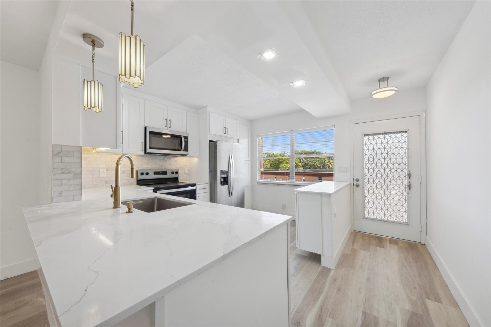 Stunning unit in Wynmoor! Overlooking scenic golf course, this spacious 2/2 has it all... renovated and redesigned from floor to ceiling. with proper permitting and code approved workmanship! Outstanding features include remodeled, open kitched w/ "New Storm Gold" Quartz countertops, solid wood cabinets w under-cabinet LED lighting; marble backsplsh & all new stainless steel appliances; luxury, high-grade vinyl plank flooring throughout; gorgeously renovated bathrooms, including redesiigned master w expanded shower and stone-floor finish; all new plumbing, fixtures & vanities; brand new A/C & water heater, all new electrical panel and wiring; upgraded light fixtures & more! Enjoy the amenties & lifestyle of Wynmoor, and peace of mind of fully renovated unit w 40-year inspection complete!