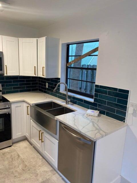 COMPLETELY RENOVATED 2 bedroom 2 bathroom apartment in duplex with large yard & grass area for outdoor living space, pets or BBQ. Very spacious roughly 1000SF with private covered front porch. Large guest bedroom closets, spacious standing showers in the master bedrooms with beautiful custom tile work & soaking tubs in the guest bathrooms, brand new ceiling fans, moderns light fixtures, completely renovated kitchens with gorgeous backsplash and never used appliances! Private washer/ dryer & private parking space for each unit! Perfect location in downtown Lake Worth, only one block West of Bryant Park and the Intercoastal!