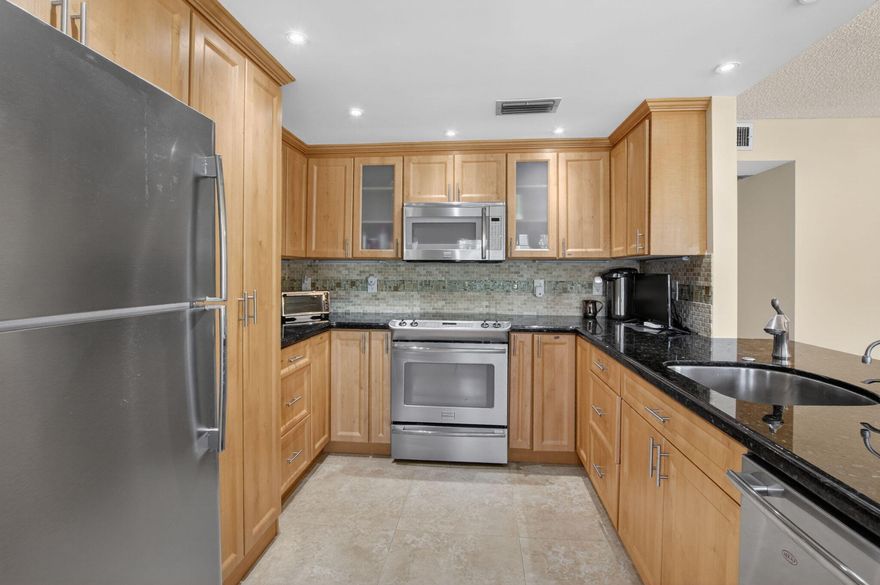 Spacious 2 bedrooms 2 bathrooms first floor condo located in the highly desirable Yarmouth B Building. Comes fully furnished turnkey and move in ready. Features a modern kitchen with granite countertops, gorgeous backsplash and stainless steel appliances. Open concept with the living room and dining room. This unit is tastefully decorated. Both bedrooms have new carpet for comfort. Primary bedroom has a huge walk-in closet. Guest bedroom can also be an office. Both bathrooms are updated. Florida room has hurricane impact windows plus an amazing lake view. Located just steps from the clubhouse and places of worship. Century Village is a premier 55+ community with resort style amenities which includes multiple pools, a fitness center, card rooms, a huge theater, pickleball, and the list goes on... Must see !!!