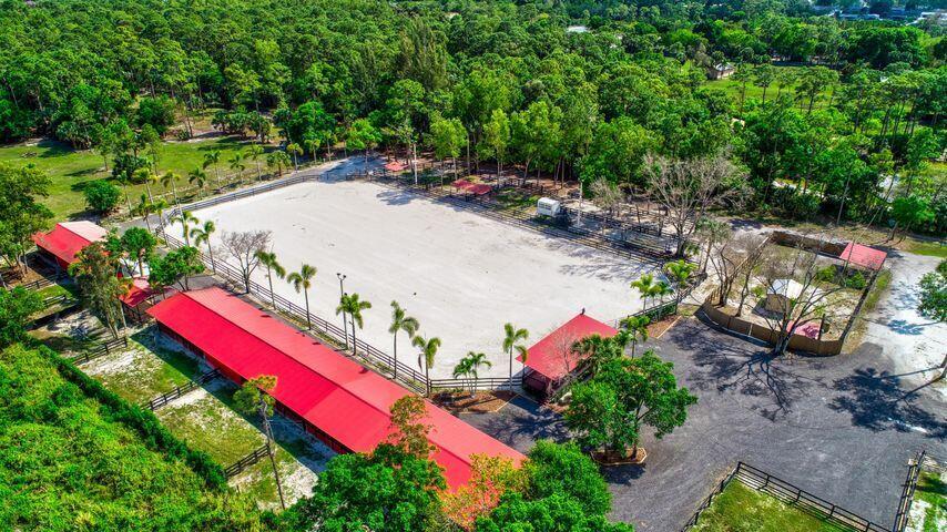 Equestrian Facility on 5 Fenced Acres, Decorative Columns with Estate Gates, Royal Palm Trees Line the Driveway, 12 Stall Barn Oversized Stalls, Large Feed Room, Tack Room, Extra Storage, Lighted Riding Ring with 250 x 150 with GGT Footing and Irrigation, 5 Wash Racks, Pavillion, 7 Paddocks, Large Pasture with Irrigation, No Pond, Trailer Parking, Great Location, Minutes to Wellington Show Grounds, NO HOA, Must See