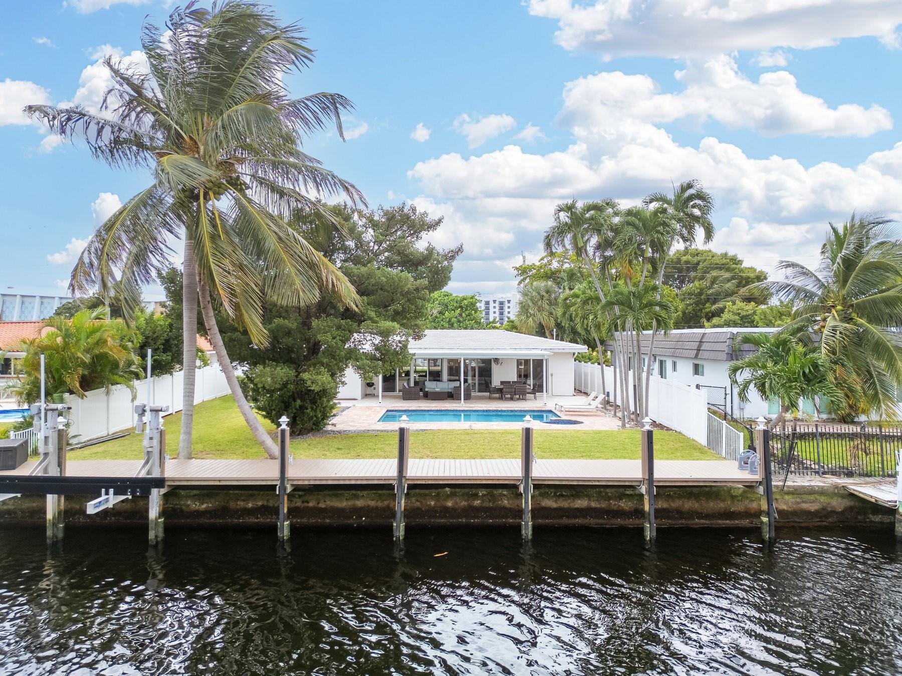 Bring your boat and embrace the ultimate South Florida lifestyle! Experience the best of Fort Lauderdale waterfront living in this beautifully renovated and fully furnished 3-bedroom, 3-bath home. Inside, you’ll find marble floors, a split floor plan, and a gourmet kitchen. Enjoy peace of mind with a newer roof, impact windows, and a brand-new A/C unit. The primary suite features a walk-in cedar closet, offering both charm and functionality. Step outside to 85 feet of water frontage, a private dock with ocean access (one fixed bridge – Sunrise 10’ at high tide), a travertine pool deck, jacuzzi, and spacious covered patio ideal for indoor-outdoor living. Situated on a quiet, dead-end street east of US-1, this turnkey home is truly move-in ready—your waterfront oasis awaits!