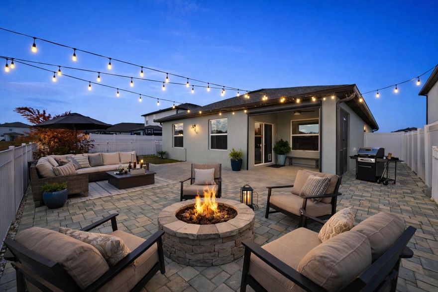 Lakefront Eden model, 2021 build in Waterstone. 4 bedrooms, 2 baths, 2-car garage, split floor plan with open great room (Virtual Furniture Staged). Carpet-free floors, upgraded 18-inch sealed tile. Island kitchen with granite counters, soft-close cabinets, and newer appliances. Custom lighting, fixtures, and window treatments. Covered lanai is fully screened with a motorized retractable screen panel. Fenced, east-facing backyard finished with large tile plus brick pavers, set up for low-maintenance evening entertaining with lake and wildlife views. Side yard fruit trees: mango (2 varieties), plantain, jackfruit, cherry, and avocado. Key West shutters allow hurricane panels, gutters, extra insulation, irrigation, and a manual pull-down garage screen for airflow and bug-free ventilation. City water and sewer.