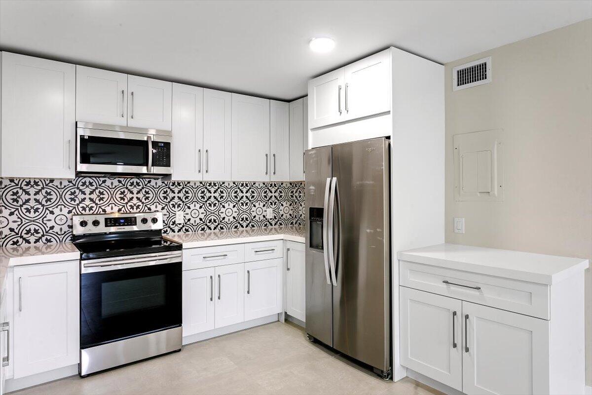 Come see this rare 2BR + DEN, 2BA FIRST FLOOR end unit that is fully renovated with modern finishes throughout. Located in the highly desirable all-age community of Waterside Village. Features 32x32 Porcelain tile flooring, a redesigned kitchen with quartz countertops, shaker cabinetry, designer backsplash, and stainless-steel appliances, along with a laundry room equipped with a full-size washer and dryer. Additional features include Accordion Shutters, Water Heater 2017, A/C 2019, and storage closet across the entrance. This move-in ready condo offers the opportunity to enjoy a comfortable and active lifestyle in a prime location.Waterside Village provides exceptional community amenities including two heated pools, spa and hot tub, tennis courts, shuffleboard, basketball, bocce,